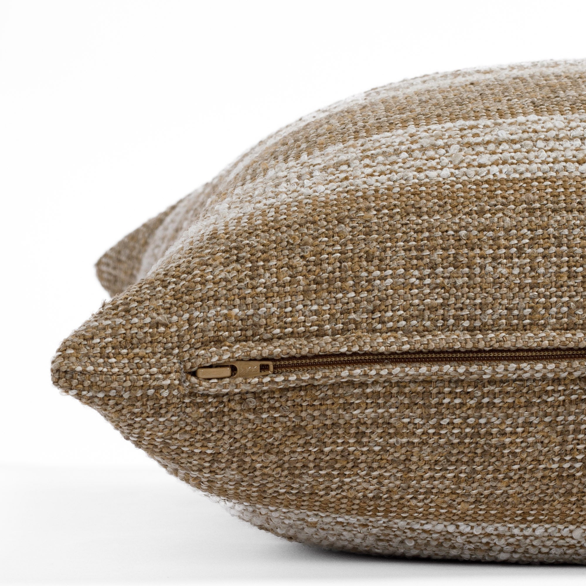 A brown and beige textured toss pillow from Tonic Living: close up zipper view.