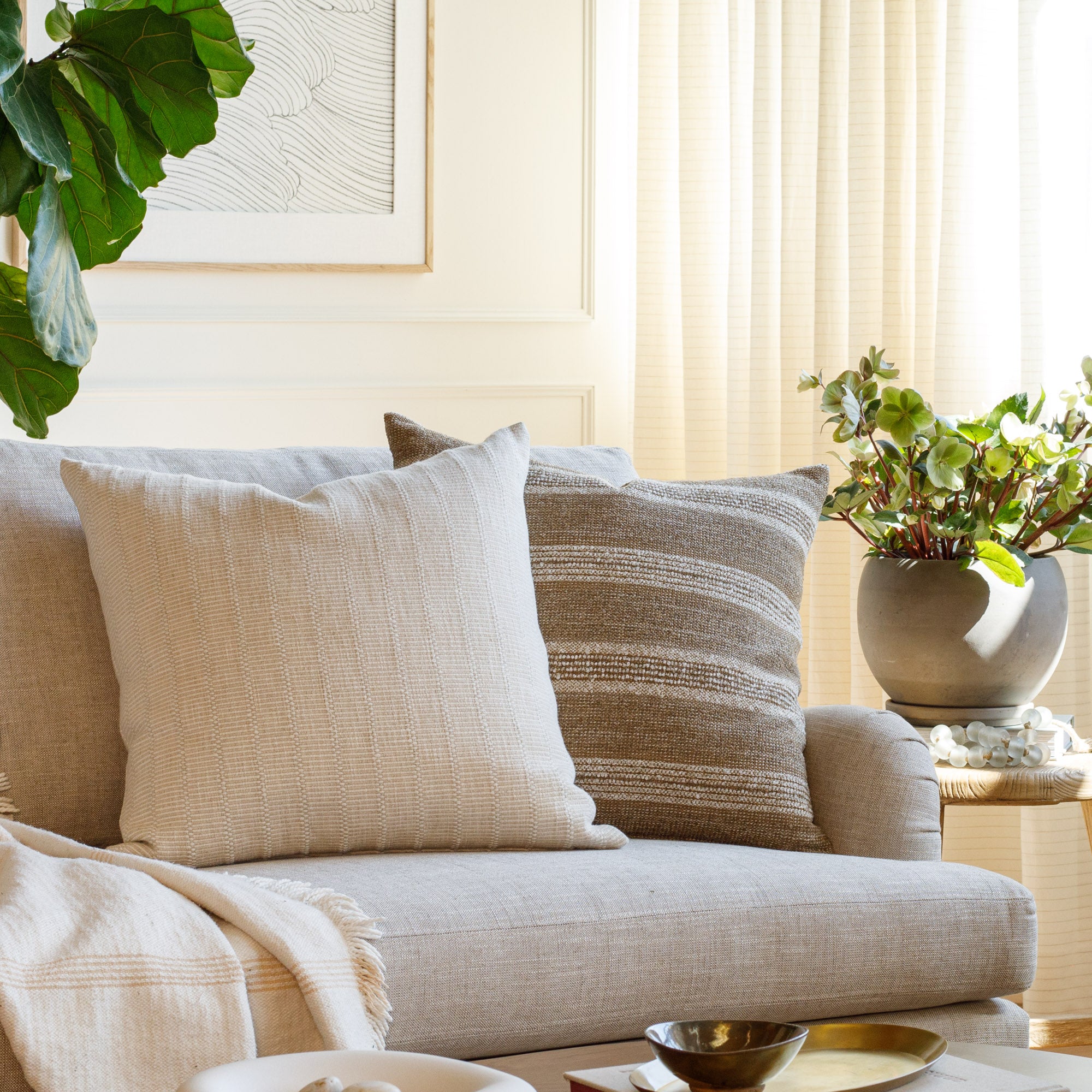 Living room with Acadia Stripe cinnamon brown and Beaumont Natural beige pillows styled on a sofa – Tonic Living