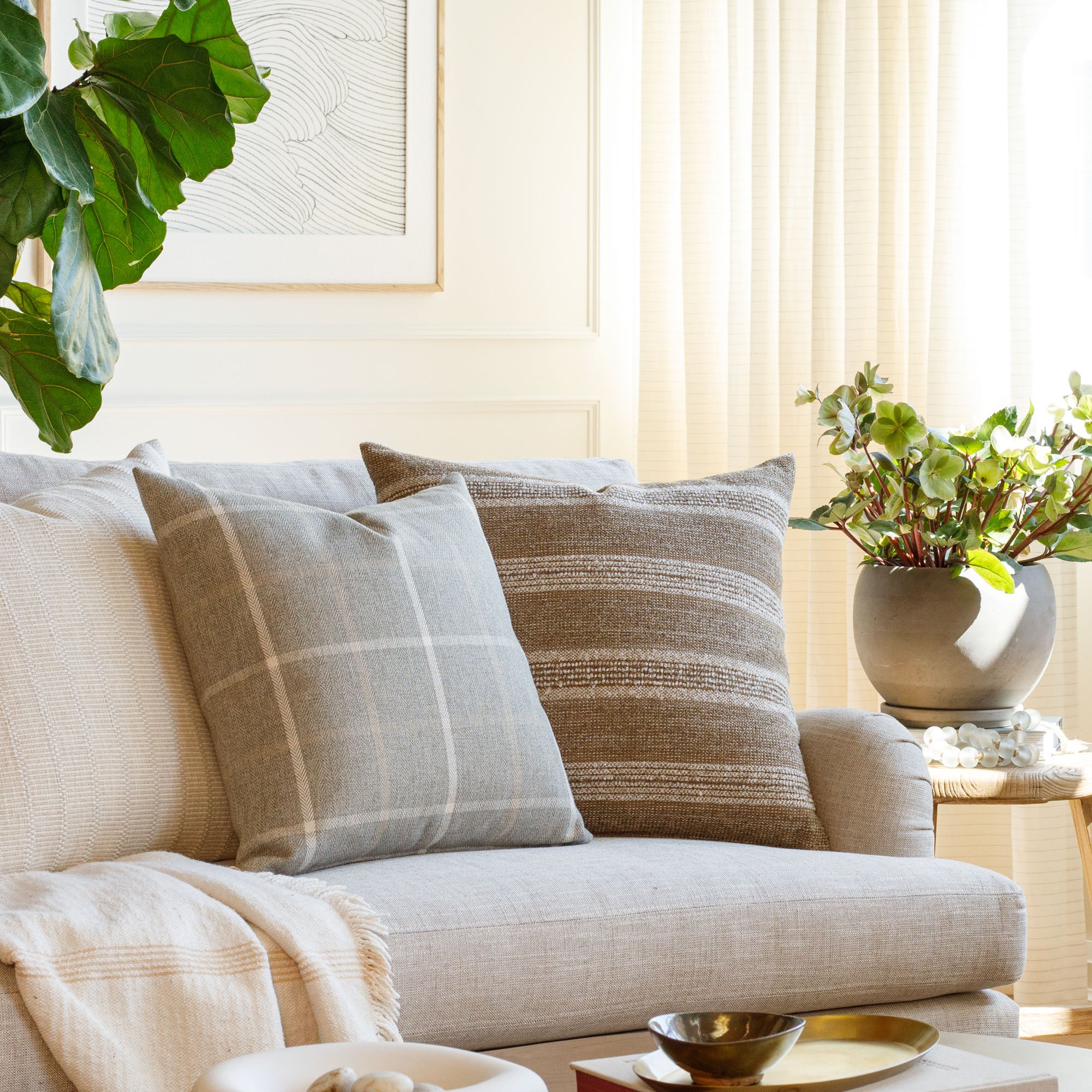 Living room with Acadia Stripe cinnamon brown and Camden plaid grey pillows styled on a sofa – Tonic Living
