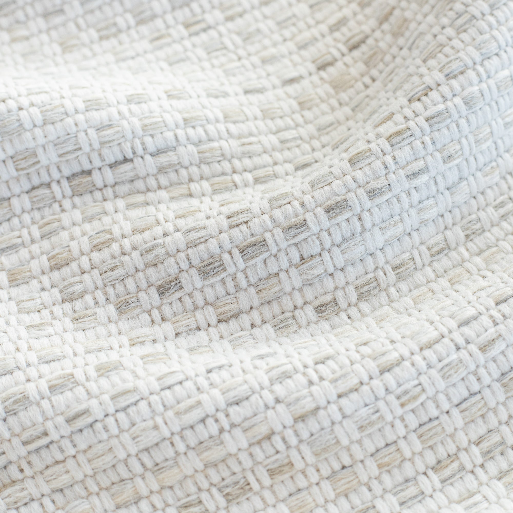 a white, oatmeal and gray basket weave textured upholstery fabric : close up view
