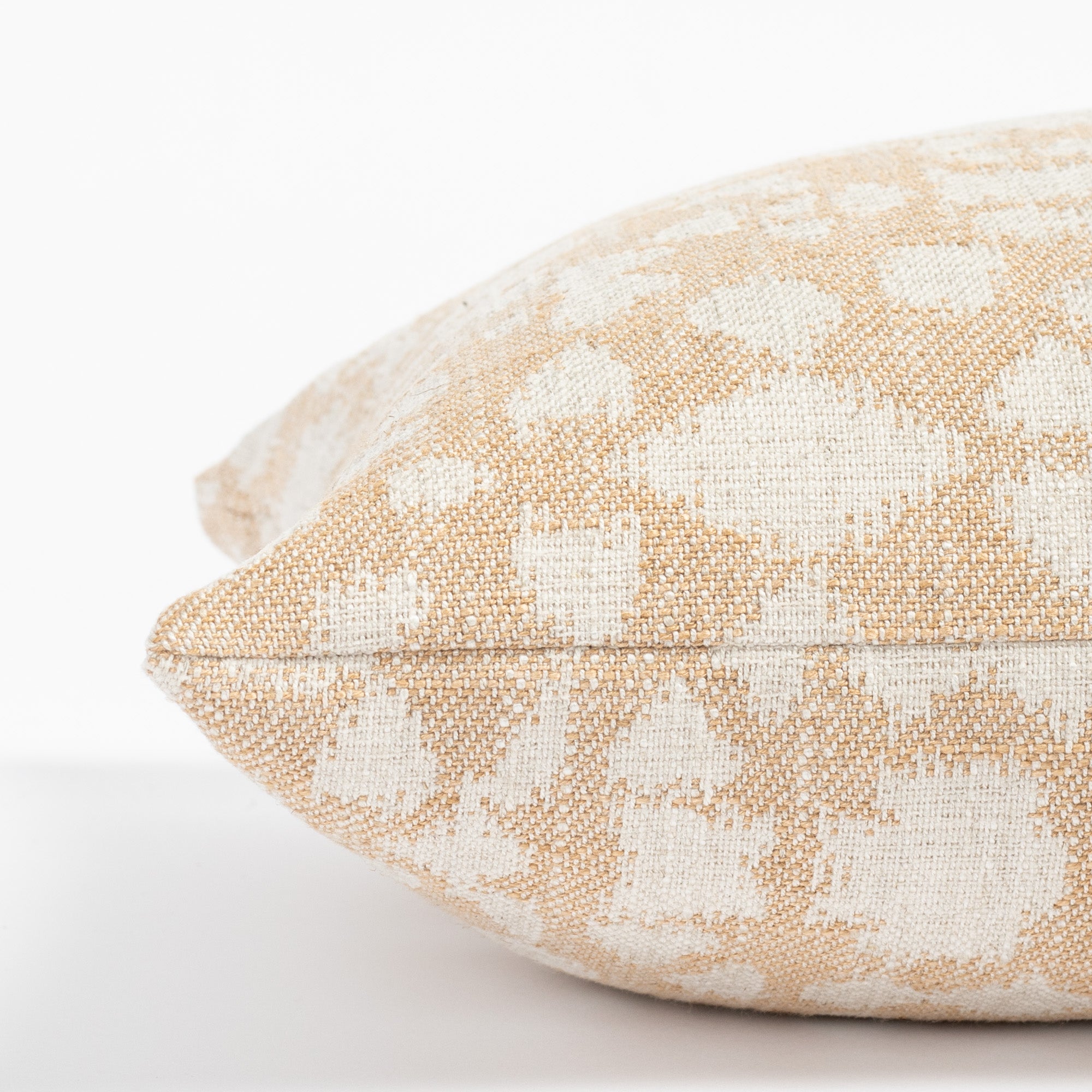 a soft gold and cream abstract floral patterned throw pillow : close up side view