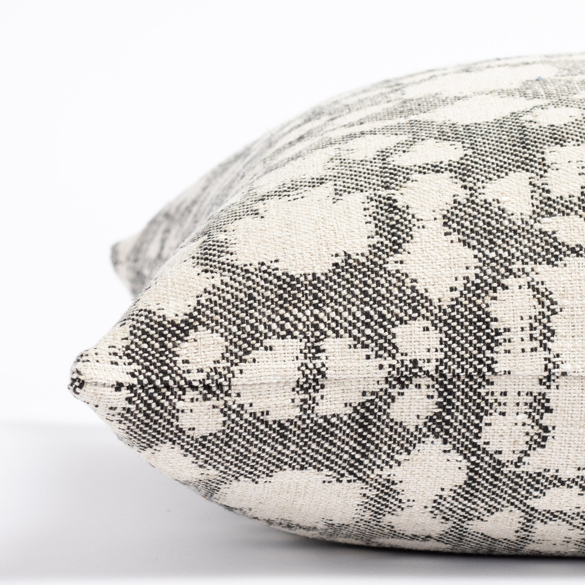 an abstract botanical patterned throw pillow : close up side view