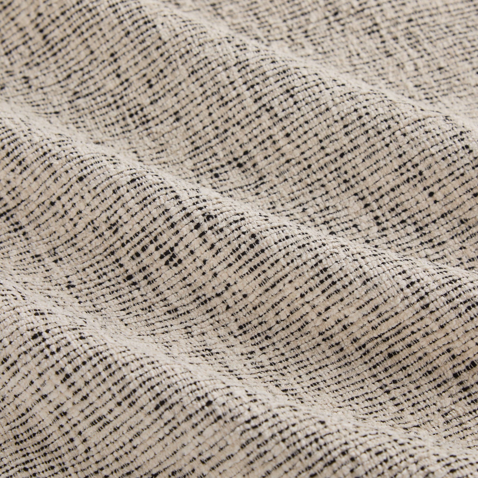 Detailed view of Atlas Fabric Salt & Pepper, fade-resistant off-white and black textured fabric by Tonic Living.