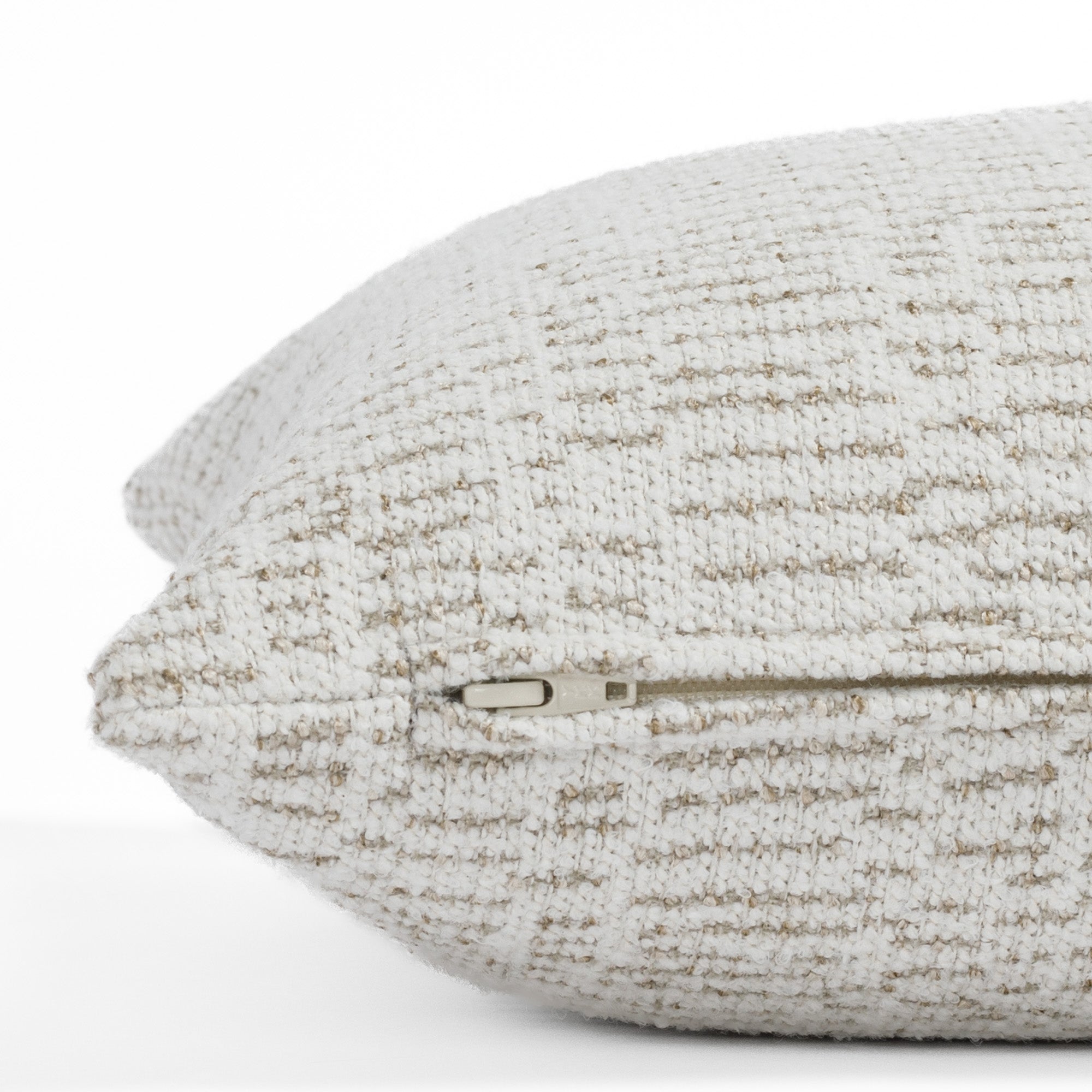 A soft white and tan patterned toss pillow from Tonic Living: close up zipper view.