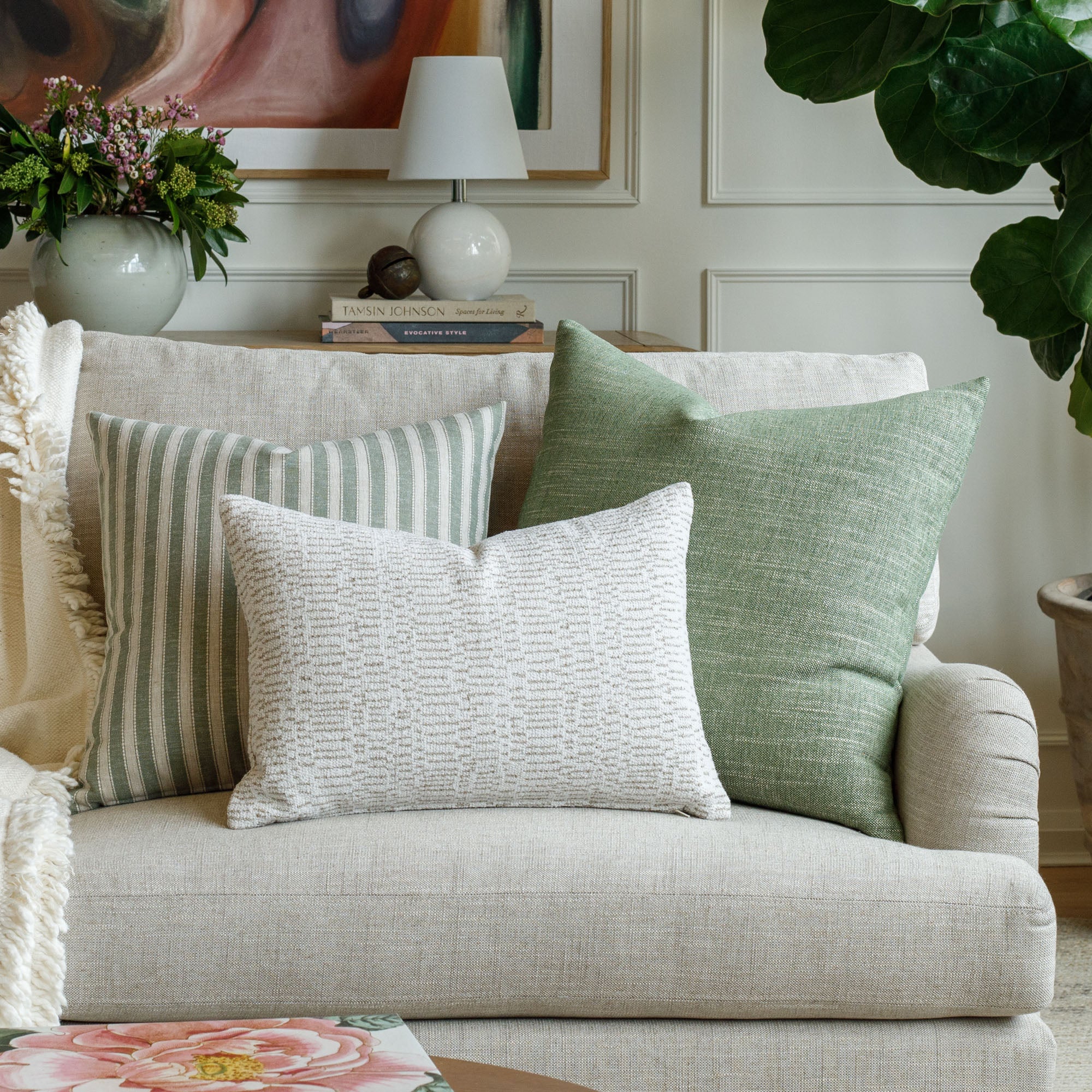 A selection of green and neutral patterned designer throw pillows from Tonic Living.