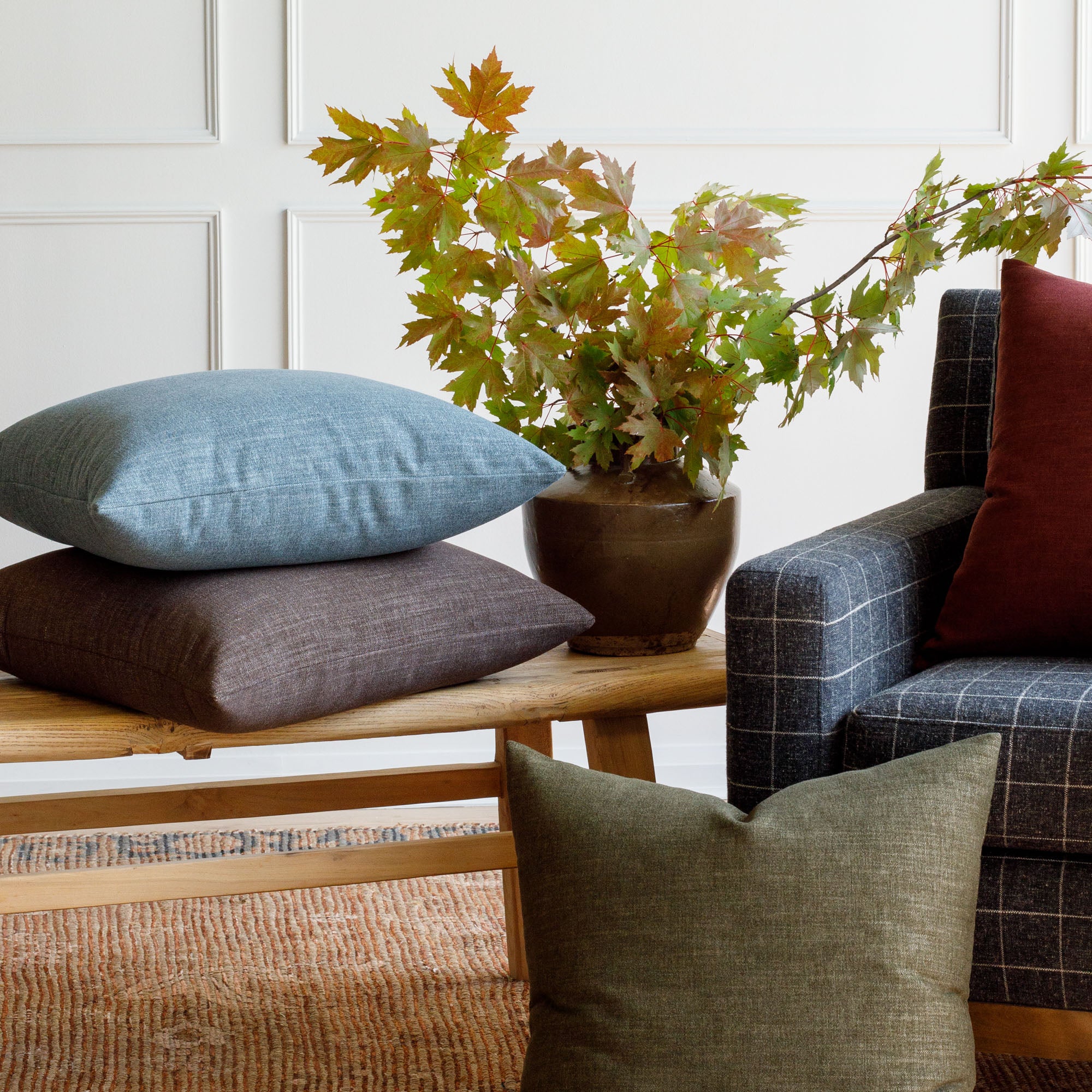 Tonic Living Bedford 22x22 pillow collection in moss green, merlot red, coffee brown and denim blue styled in living room