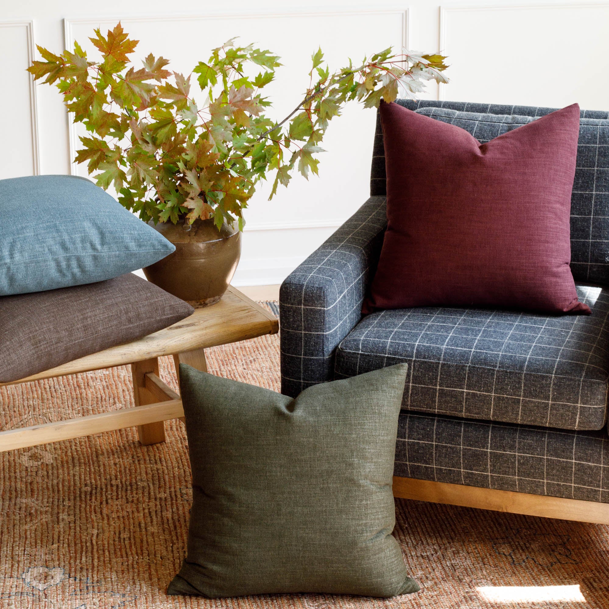 Tonic Living Bedford 22x22 pillow collection in moss green, merlot red, coffee brown and denim blue styled in living room