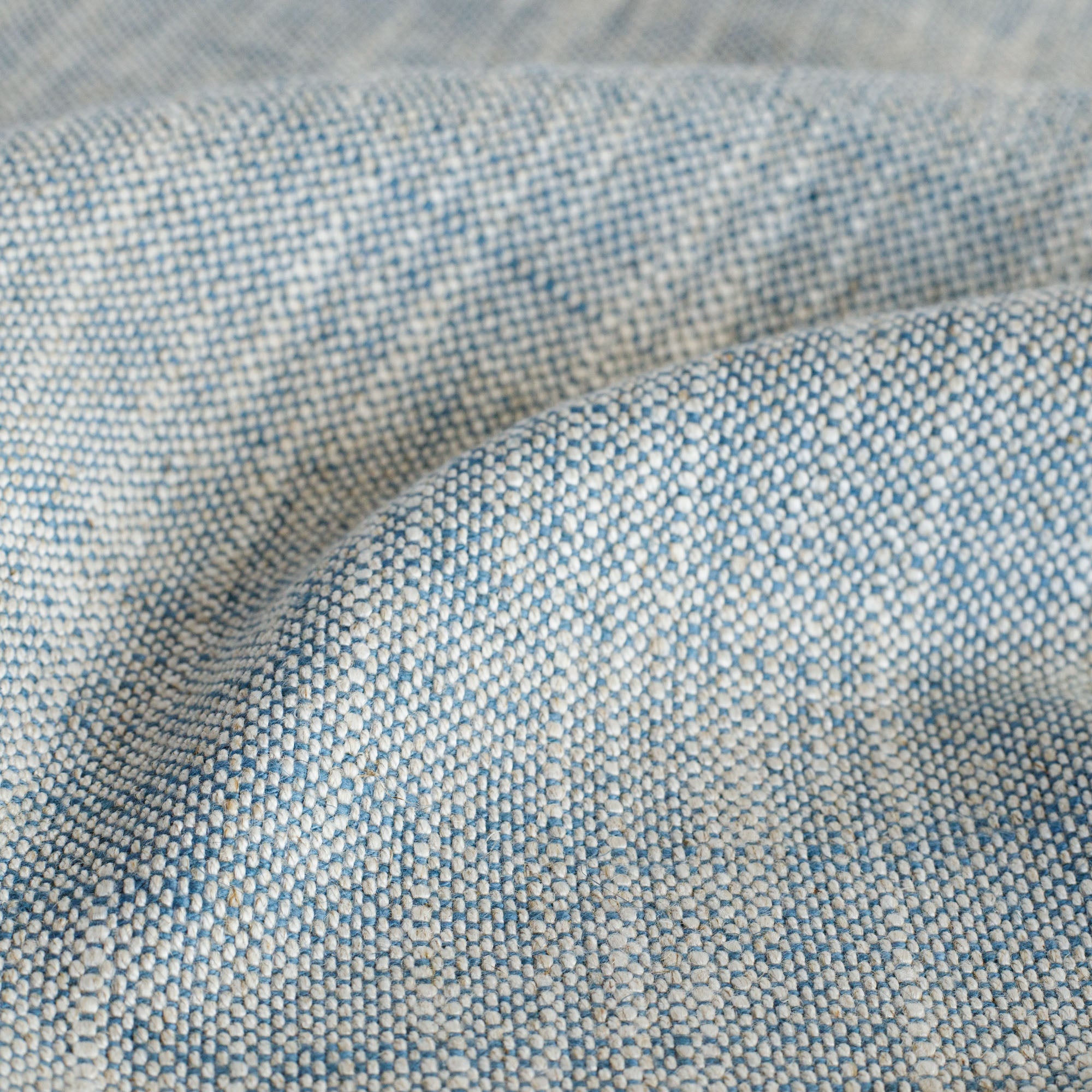 Brussels Sky Blue, a blue and beige textured high-performance upholstery fabric from Tonic Living: close up view.