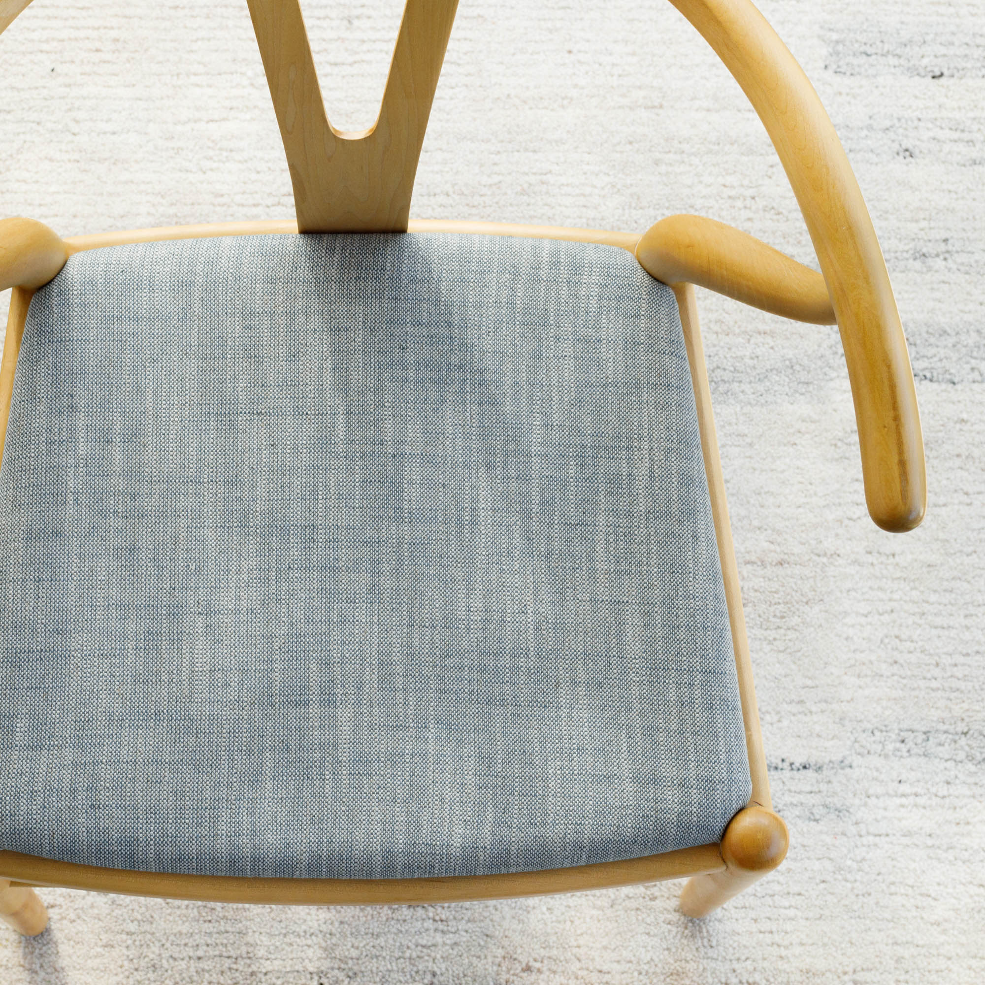 Brussels Sky Blue, a chambray blue and oatmeal slubby textured fabric from Tonic Living, upholstered on a chair seat.
