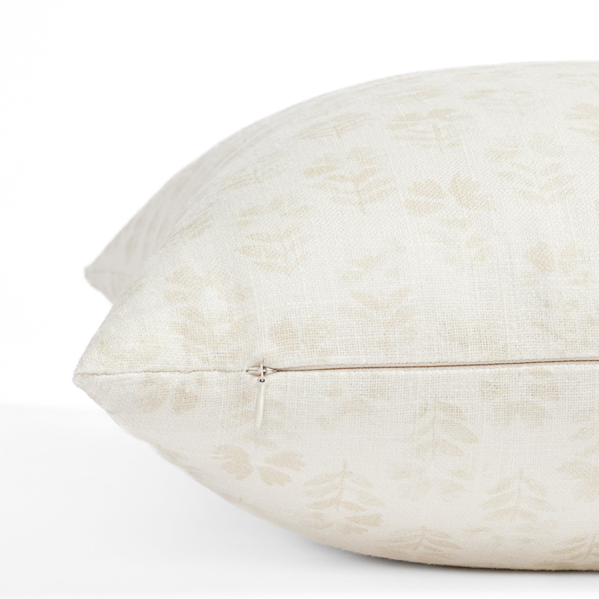 a subtle cream tonal floral block print pillow : close up zipper view