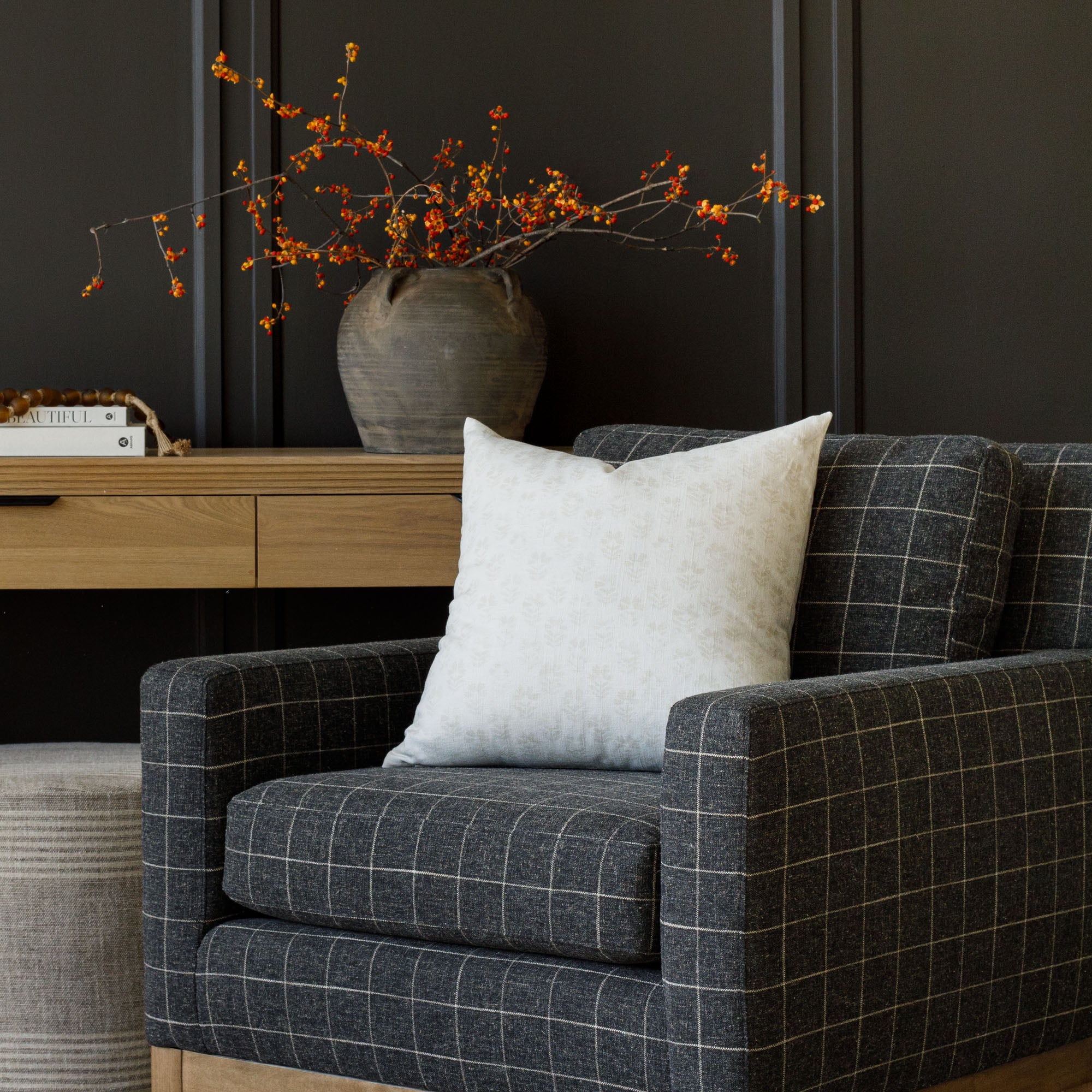 a floral cream pillow on charcoal grey windowpane check chair