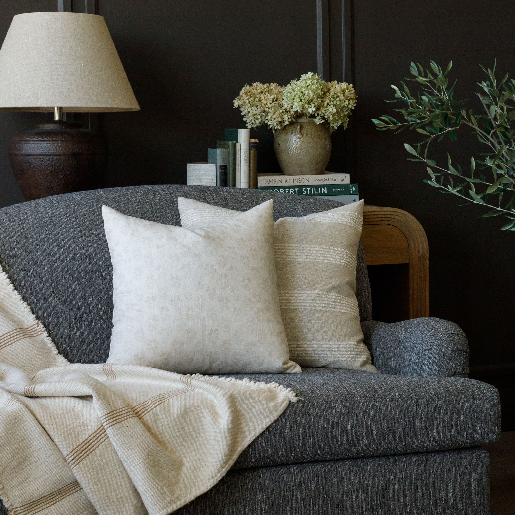Tonic Living cream patterned throw pillows on a charcoal gray sofa
