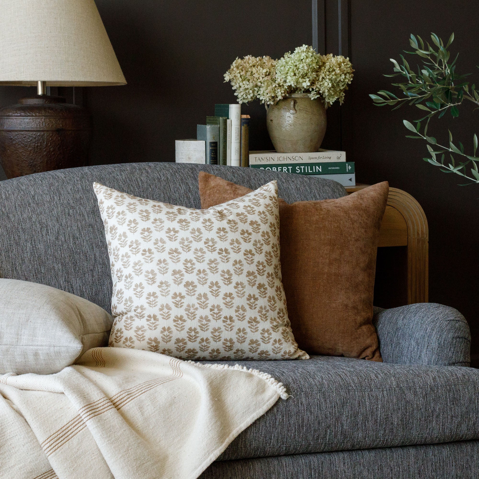 cinnamon brown and cream Tonic Living pillows on a dark gray sofa