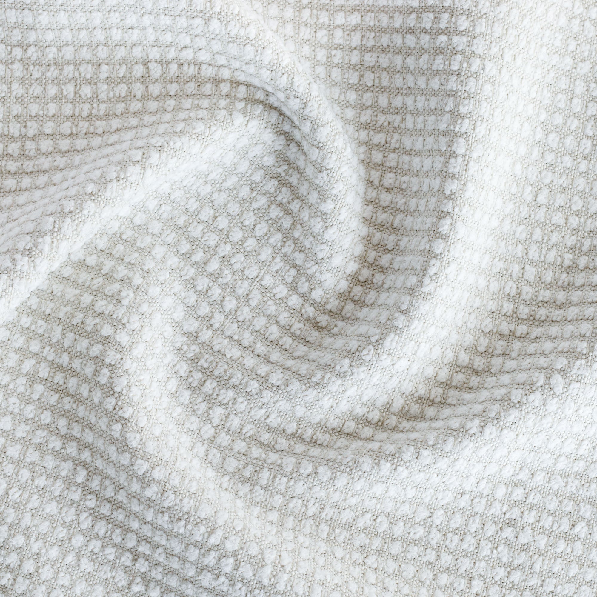 a creamy white textured grid patterned performance upholstery fabric