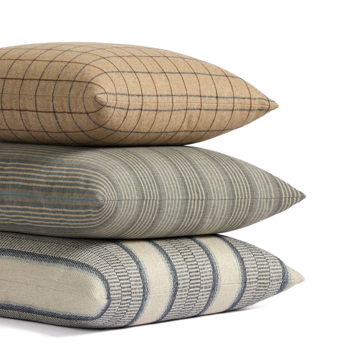 Stack of Tonic Living pillows featuring Walker Plaid, Clark Stripe, and Miller Stripe in coordinating blue, brown, and neutral tones.