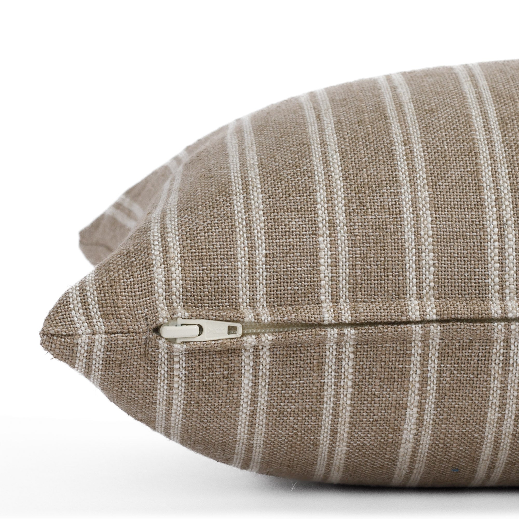 Side view of the Conway Stripe Bark 12x24 lumbar cushion by Tonic Living, showing the exposed zipper and slubby natural fabric in soft brown and beige tones