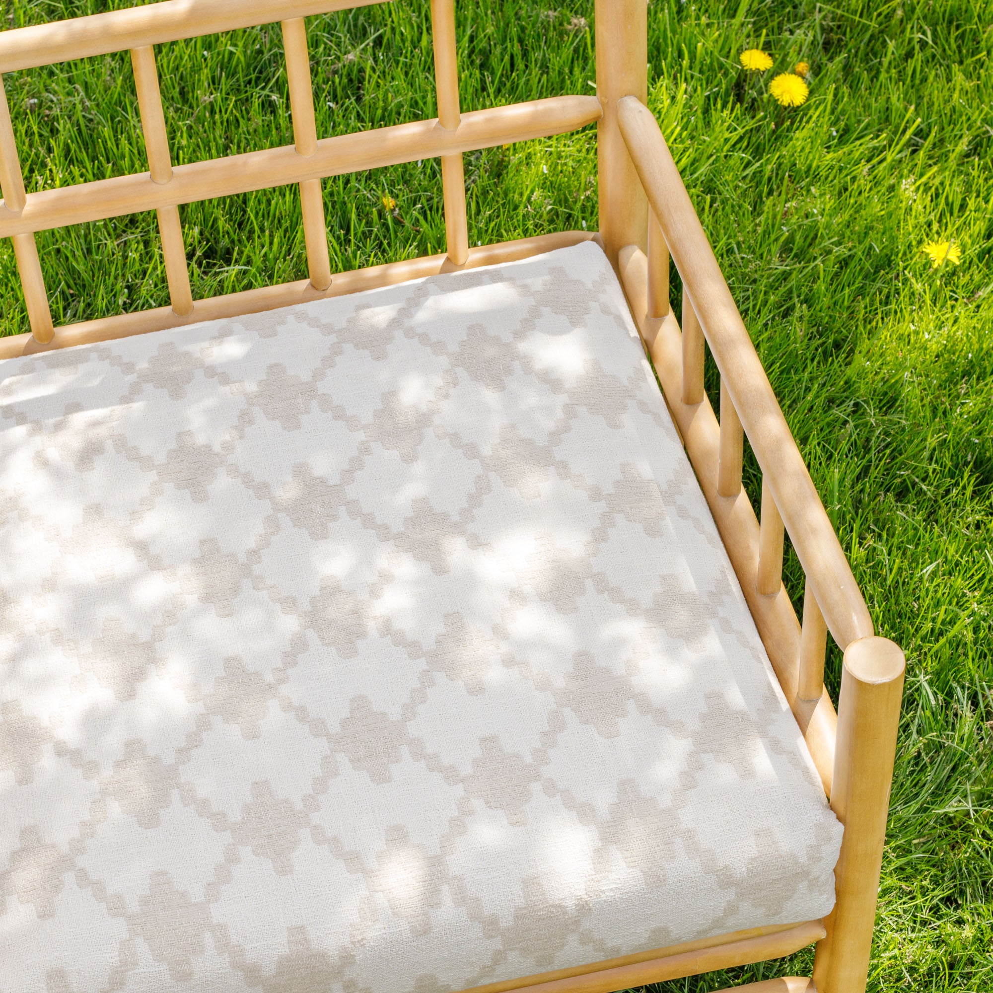 a white and beige geometric moroccan tile patterned outdoor upholstery fabric bench cushion