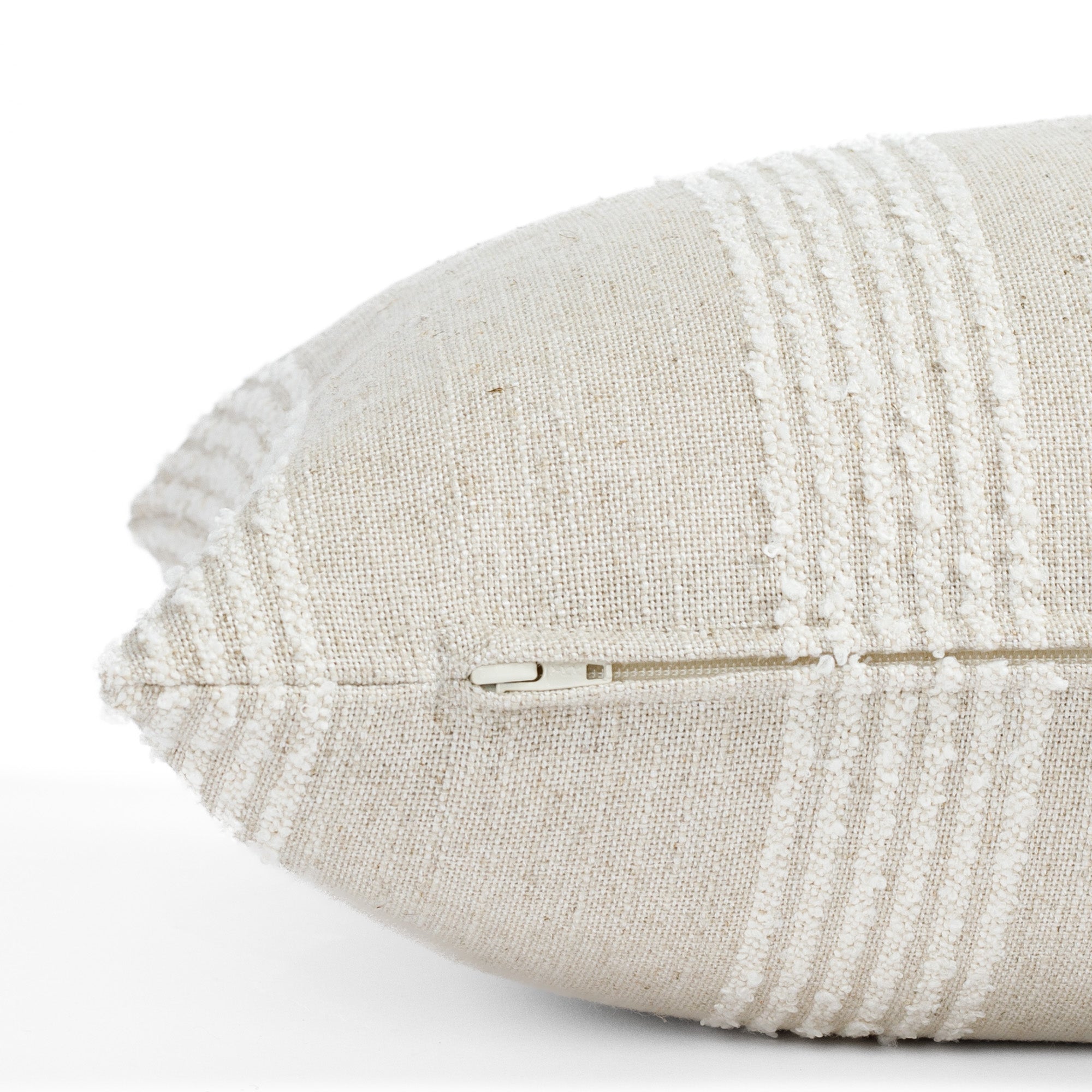 an off white and oatmeal pillow : close up zipper view