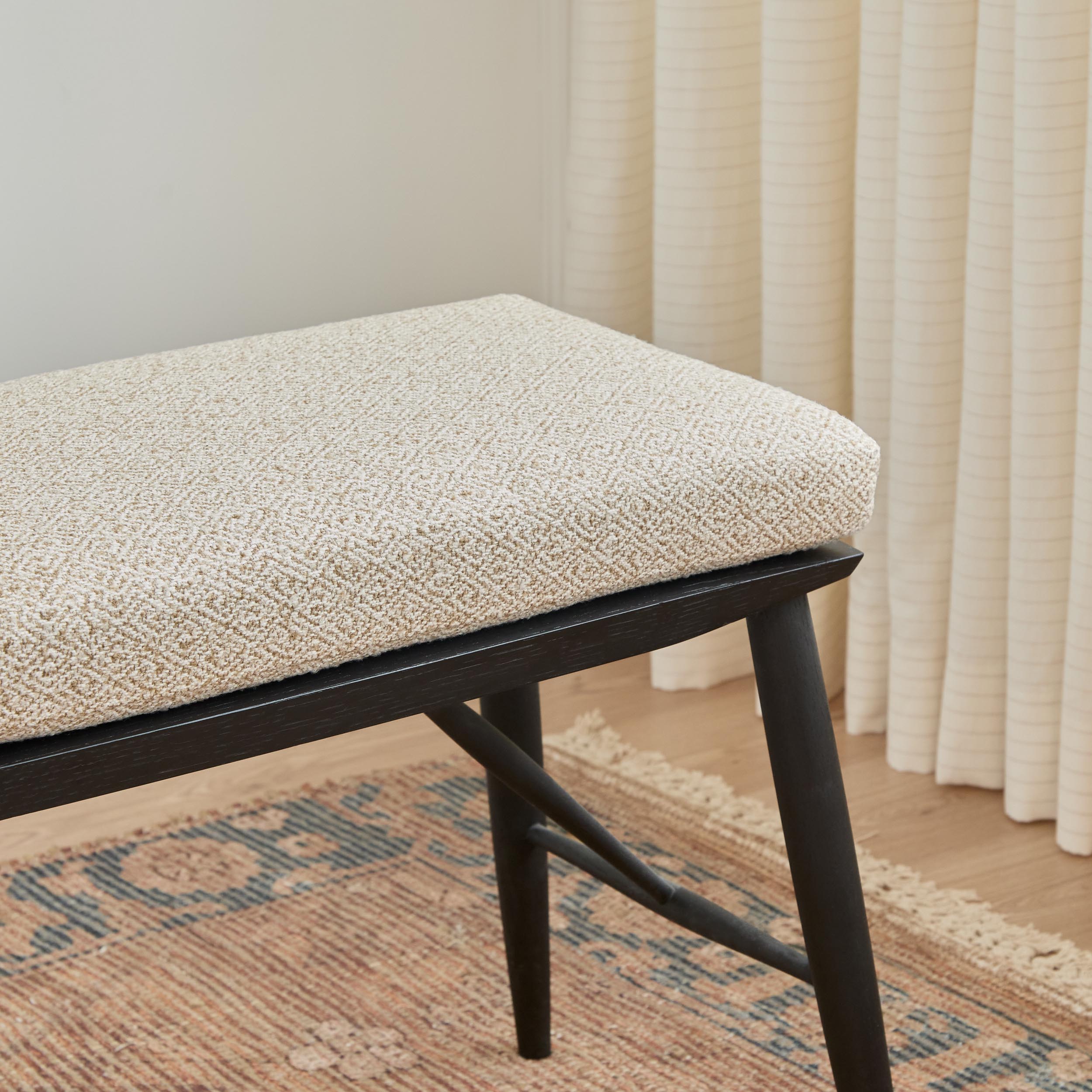 Flint Fabric, Wheat by Tonic Living — high-performance upholstery fabric in soft white and beige with a subtle diamond twill weave, shown on a bench seat cushion.