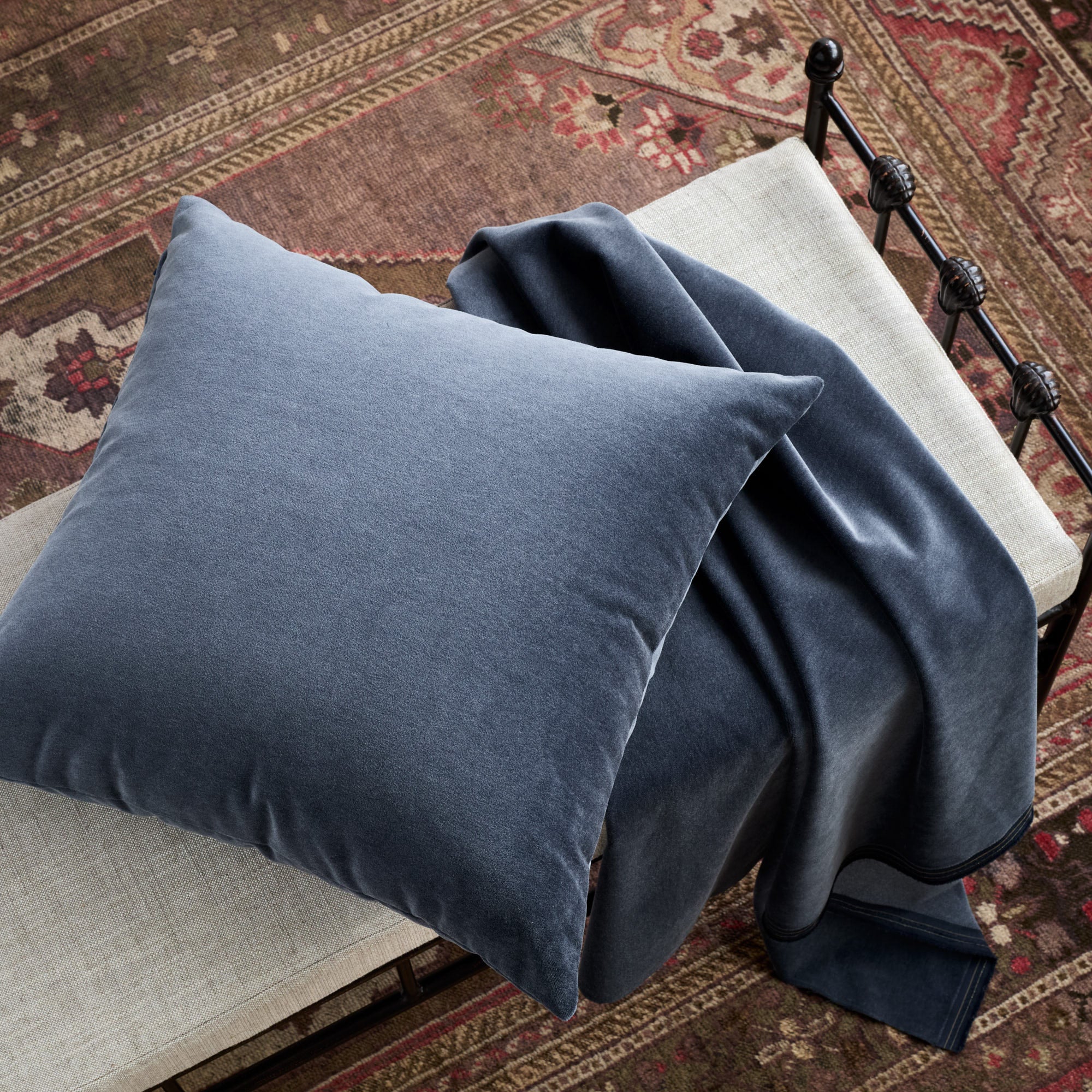 Tonic Living Florence Velvet Mineral Blue cushion styled on a bench with matching upholstery fabric.