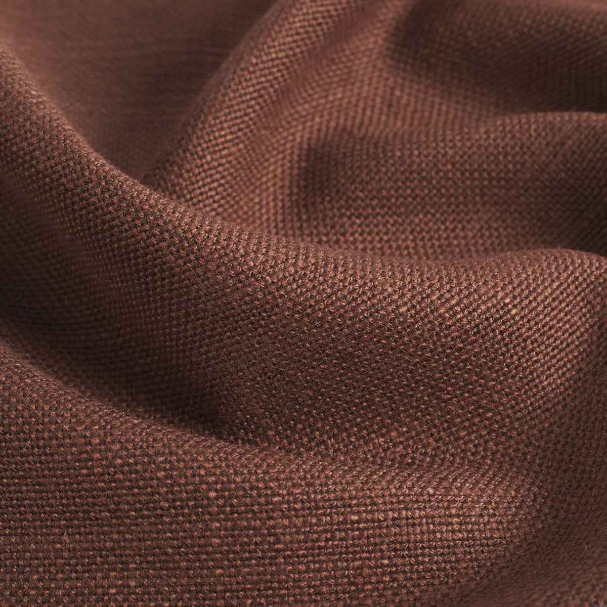 Close up of Tonic Living Hampton Burgundy upholstery fabric showing its earthy burgundy colour, subtle brown undertones, and linen-like woven texture.