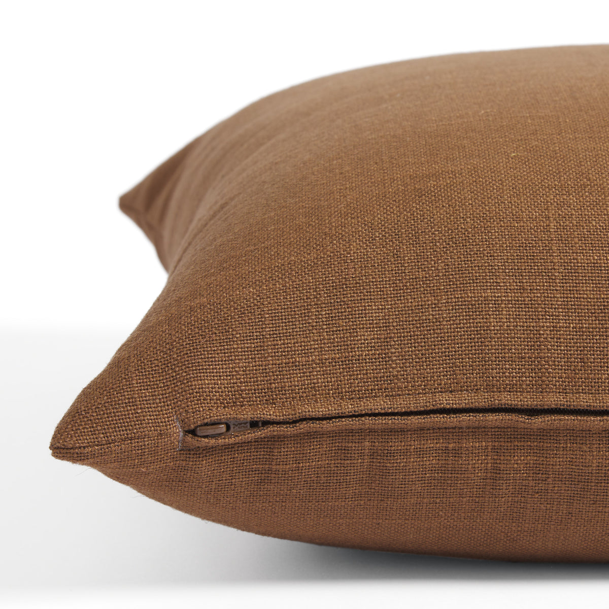 Side zipper detail of Tonic Living Hampton 22x22 pillow in warm cinnamon brown with a linen-inspired texture.
