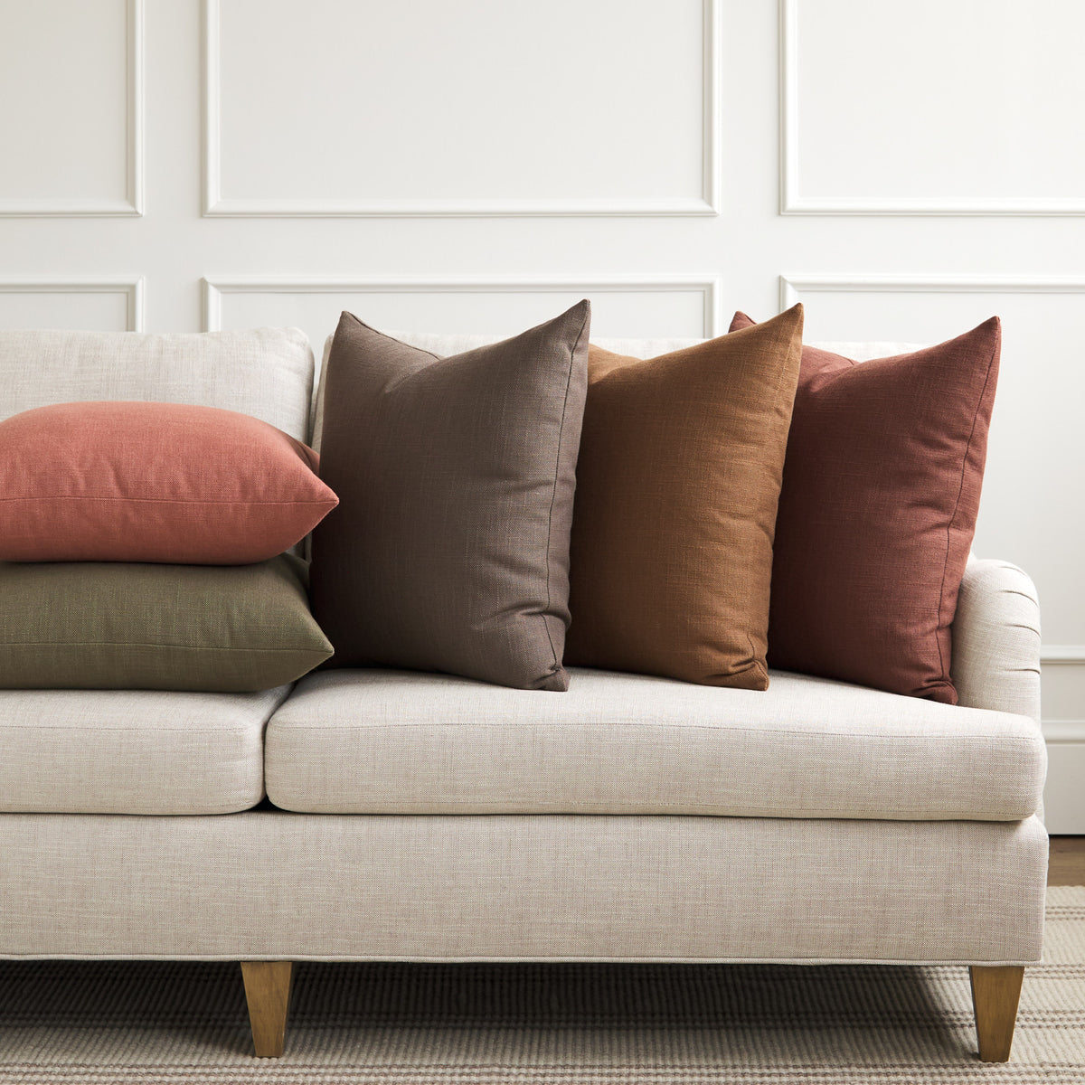Tonic Living Hampton pillow collection styled on a sofa, featuring linen-look throw pillows in a range of rich earthy colours.