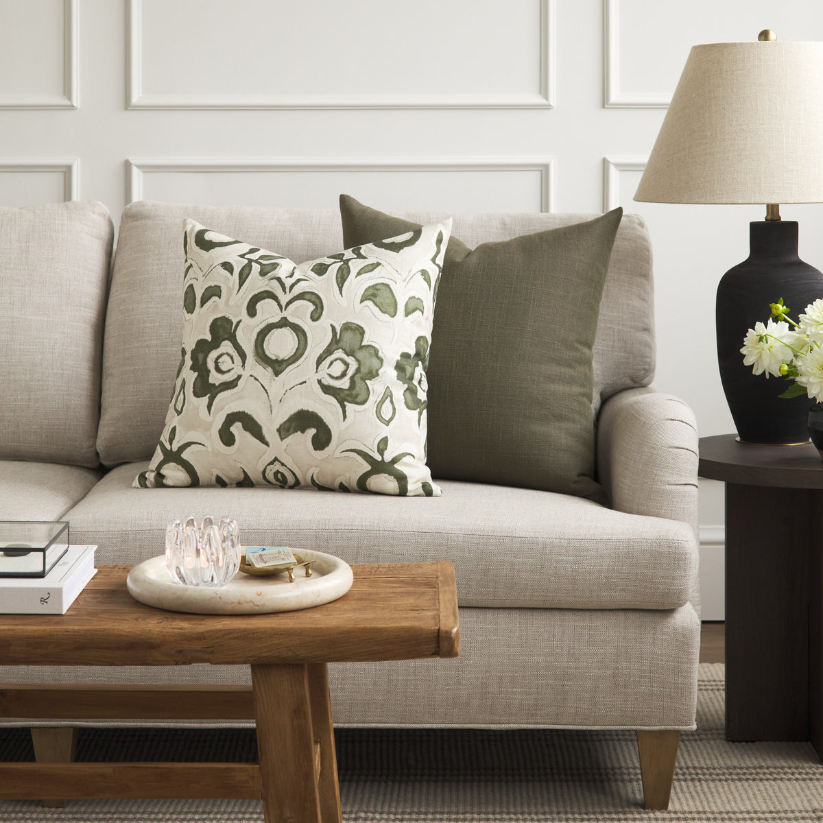 Tonic Living Hampton Moss green cushion styled on a sofa with Paloma Olive floral throw pillow.