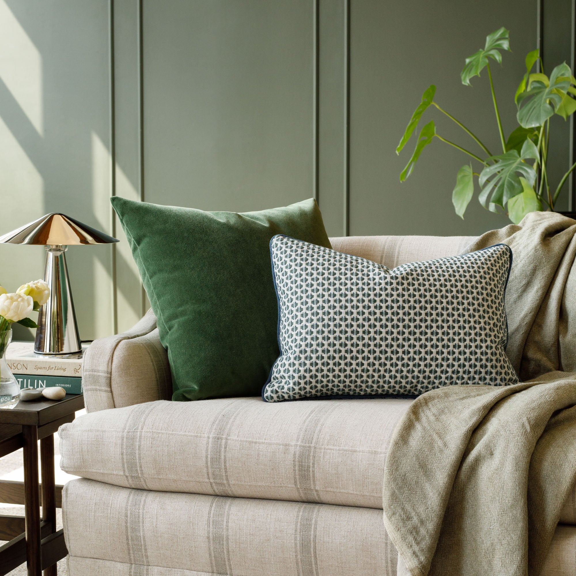 Tonic Living velvet green & geometric toss pillows styled in a rich green living room.