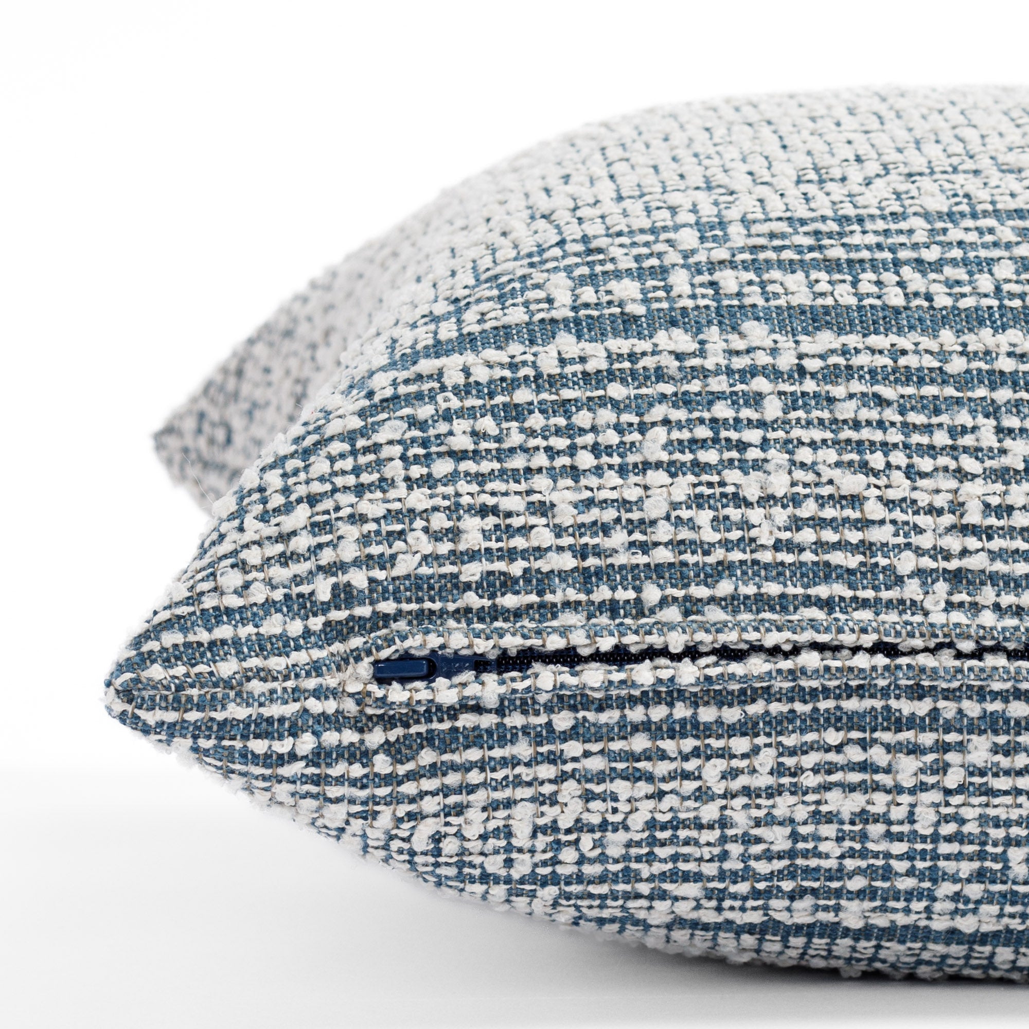 a blue and white loopy striped pillow : Close up zipper view