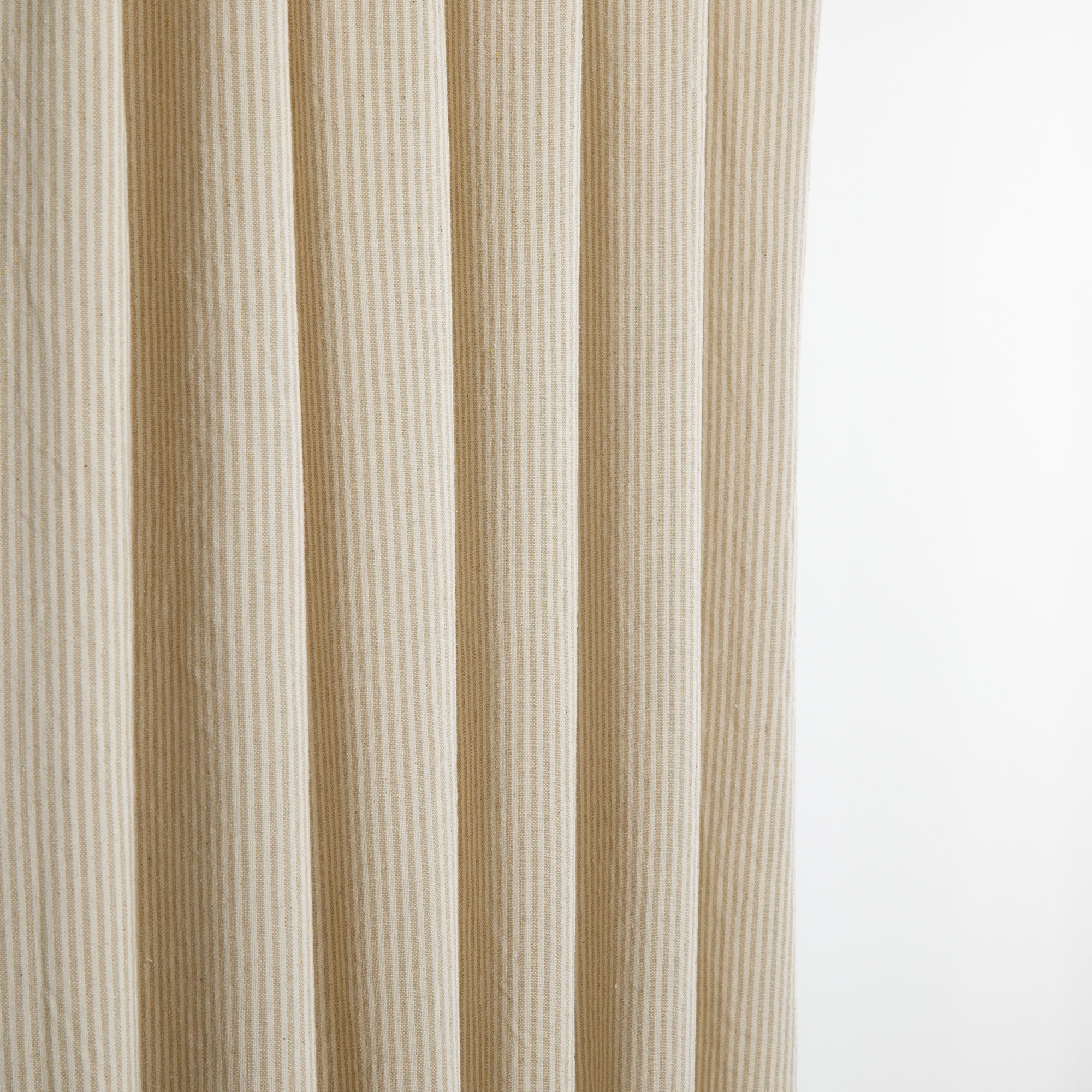 Tonic Living Leo Stripe Wheat curtain fabric shown as drapery with a beige and natural stripe design.