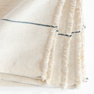 a cream and navy blue stripe cotton hand loomed throw blanket with fringe: view 6