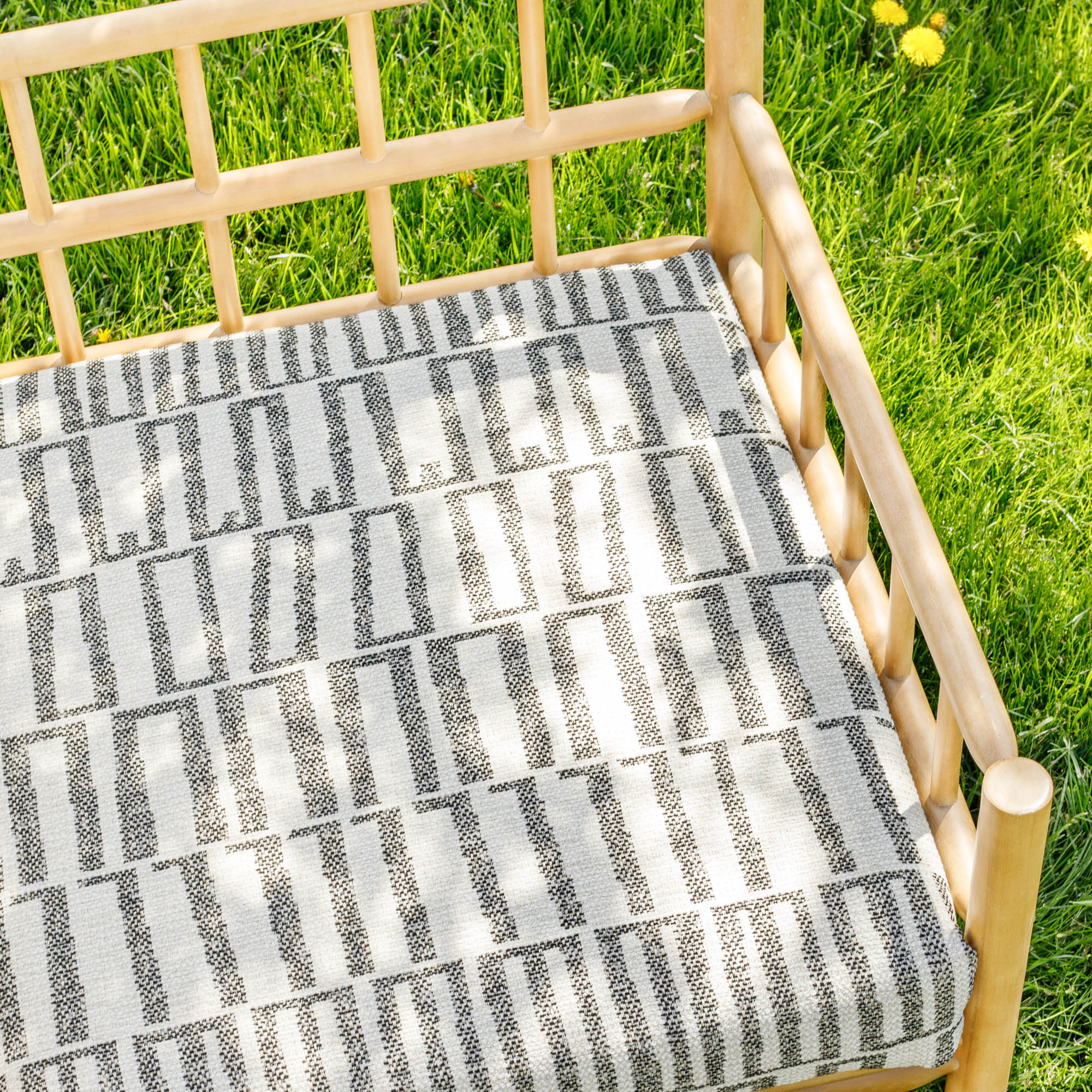 a black and sand beige geometric patterned outdoor fabric bench cushion