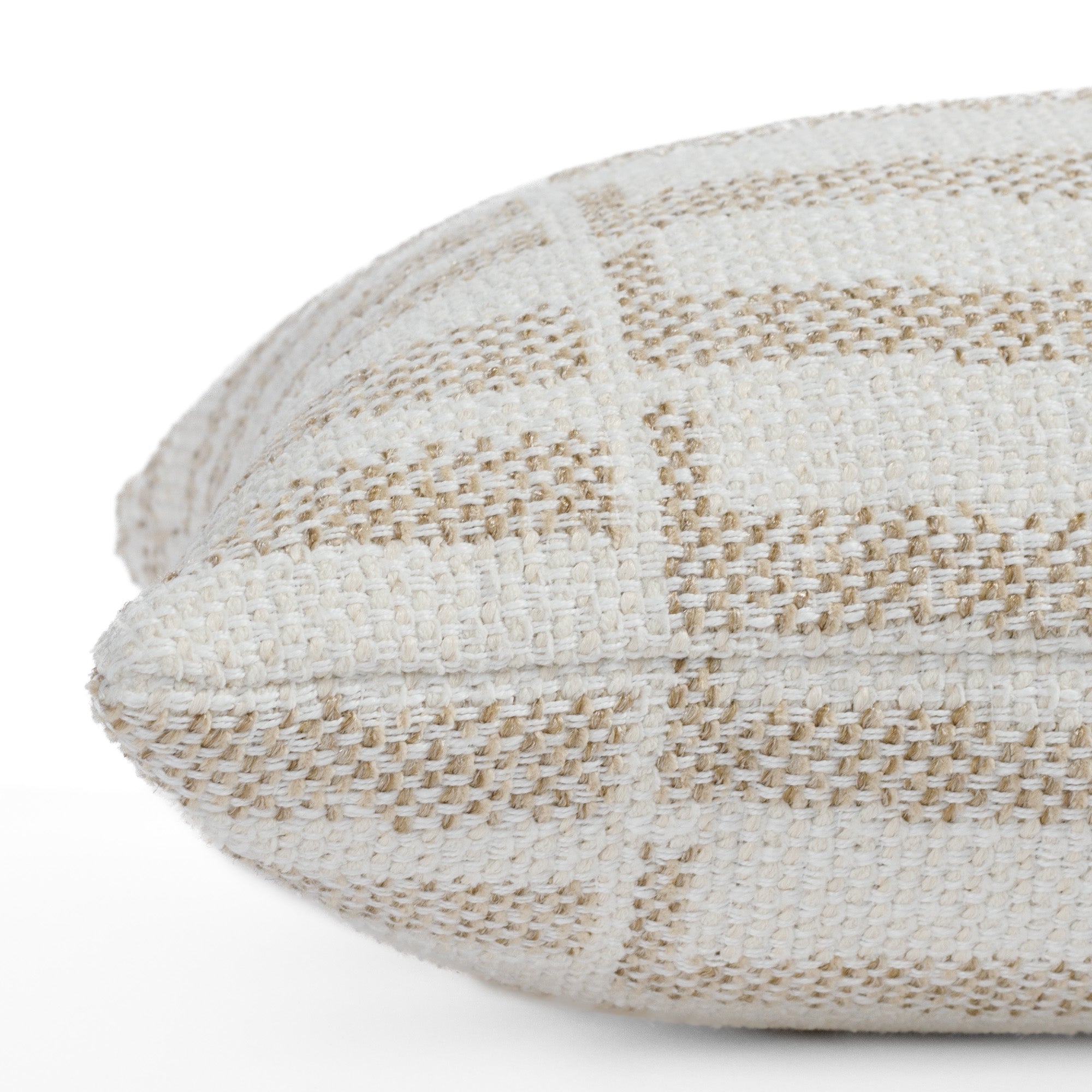 Close up side view of the Mallia Toasted Coconut 12x24 lumbar (small bolster pillow) from Tonic Living, emphasizing the soft woven texture and stain-resistant nutty beige and ivory geometric pattern.