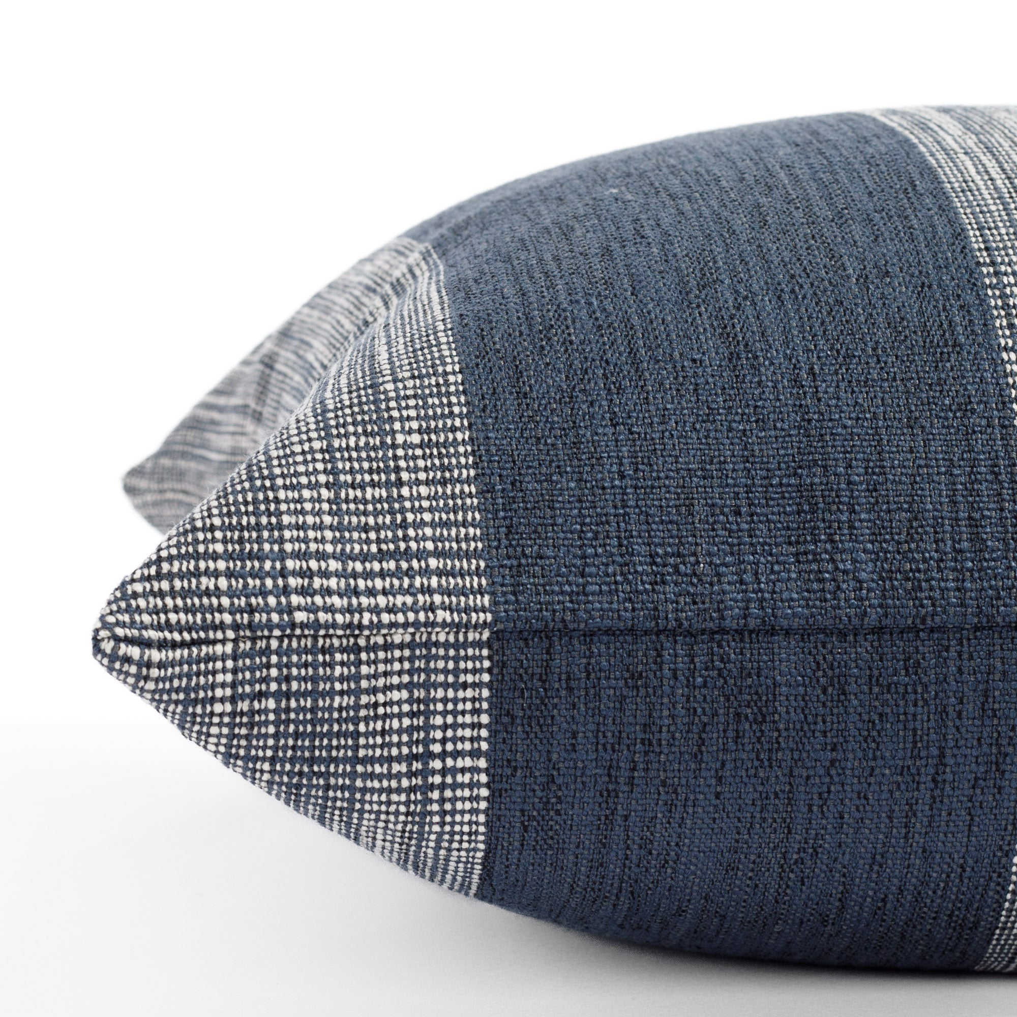 an indigo blue and white striped pillow : close up side view