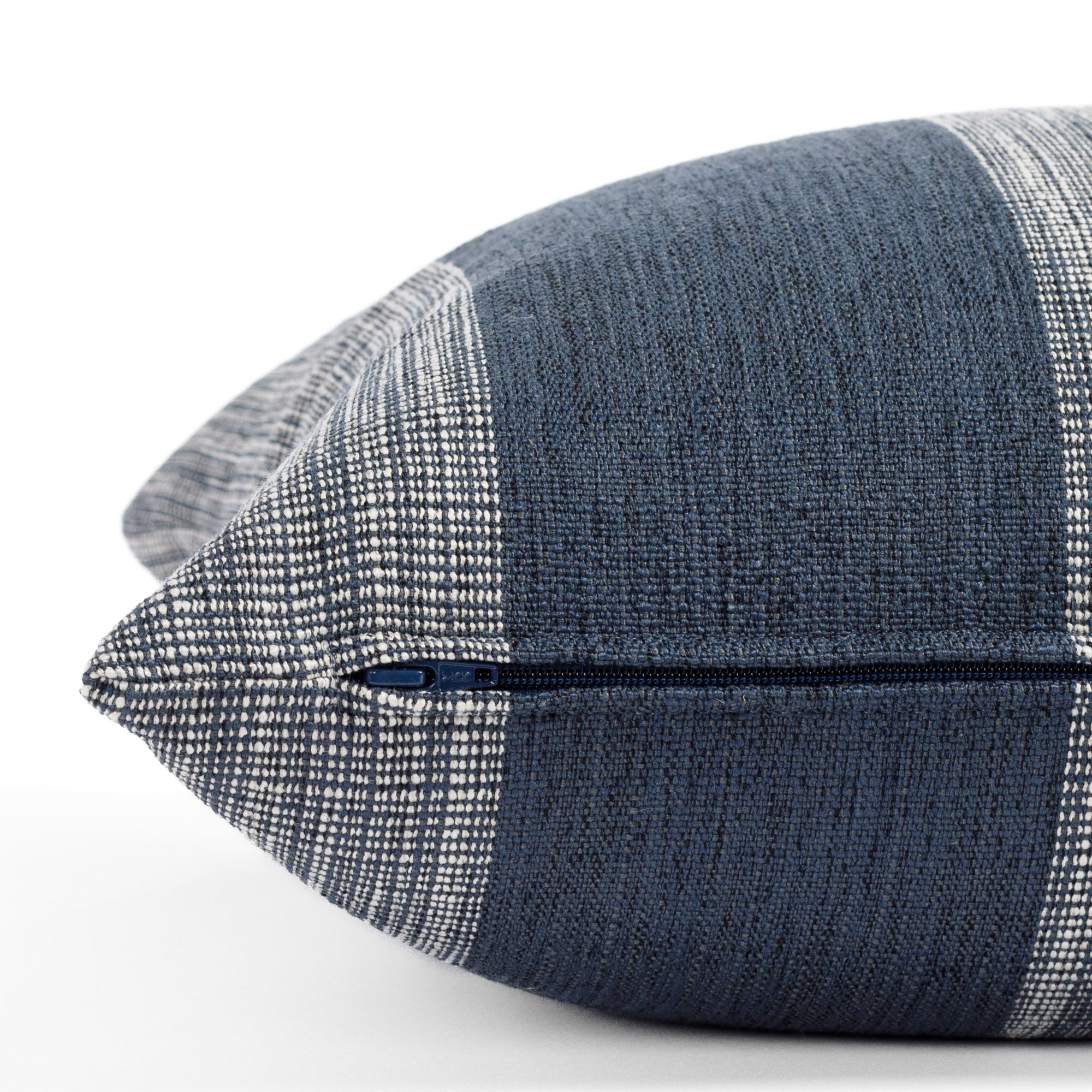 an indigo blue and white striped pillow : close up zipper detail