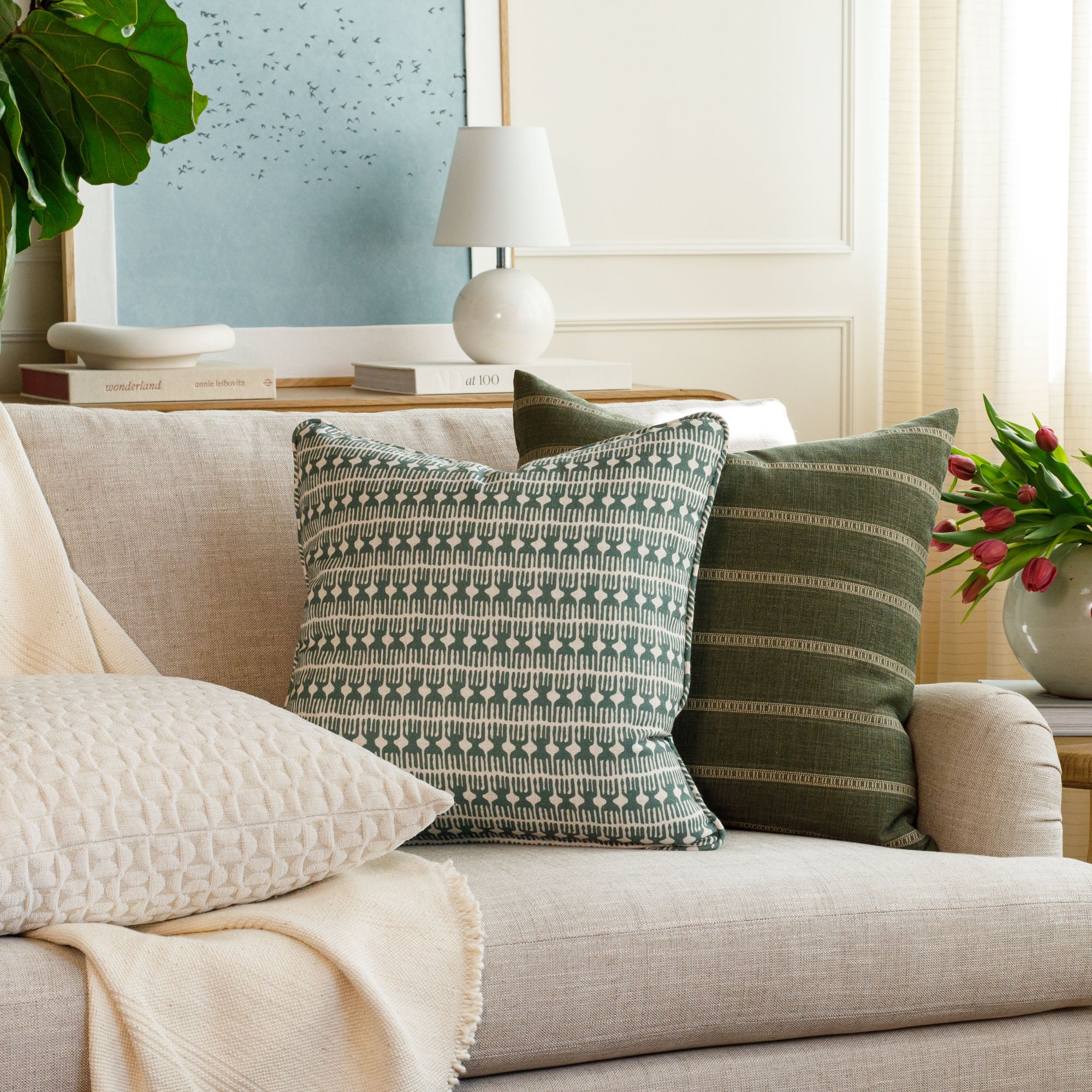 Meadow Emerald 20x20 green and white toss pillow with bold block print, styled on a sofa in a contemporary living room with Brunswick Stripe Moss pillow by Tonic Living.