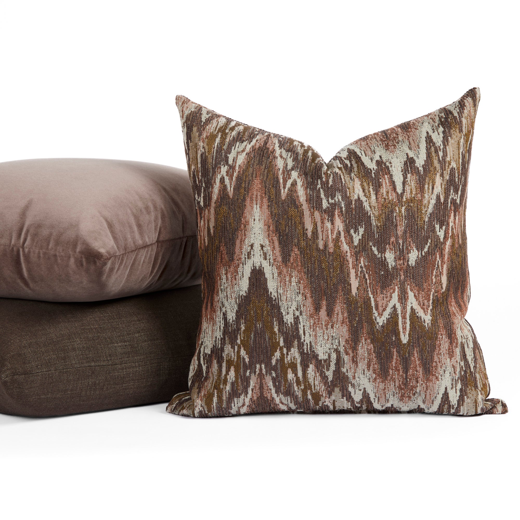 Tonic Living Mendoza Fig decorative pillow centered in front of purple and brown cushions.