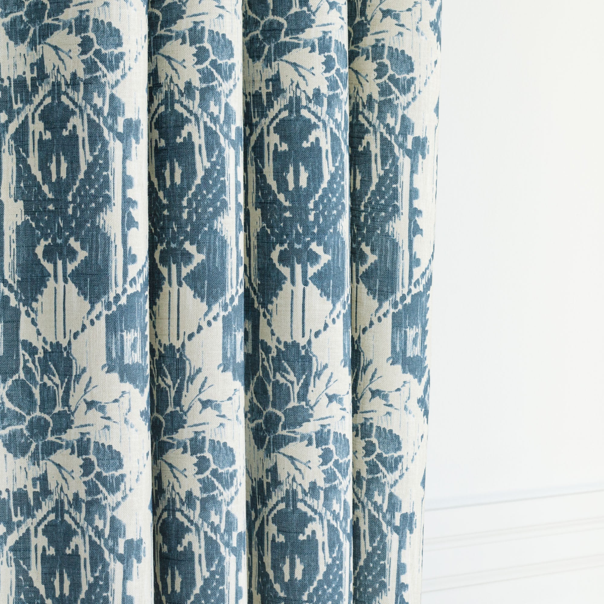 a cream and blue botanical ikat print drapery fabric