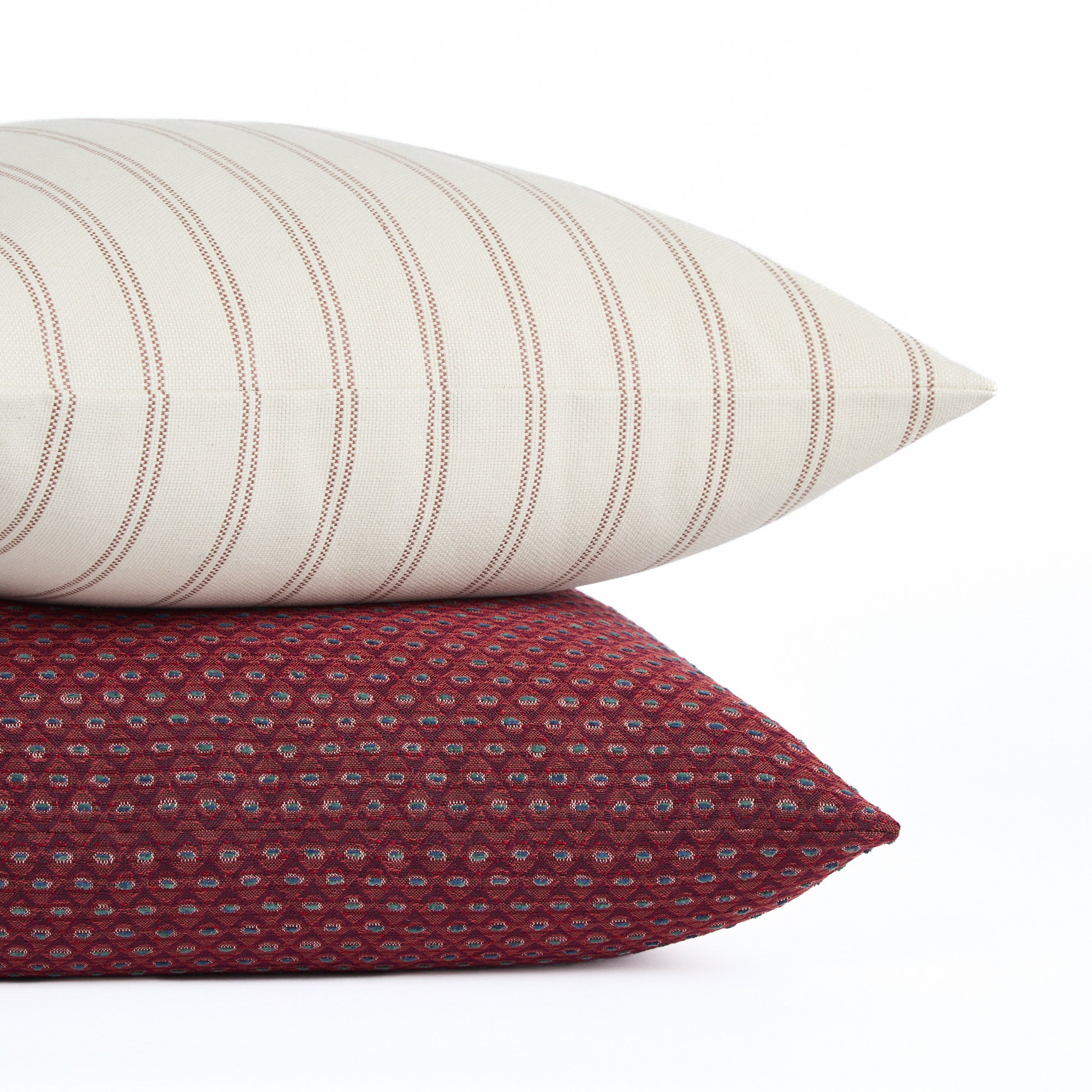 Stack of Pembrook 20x20 burgundy red pillow with Rexton Stripe cushion in beige and burgundy, Tonic Living.