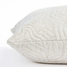 a quilted white abstract patterned pillow : close up side view