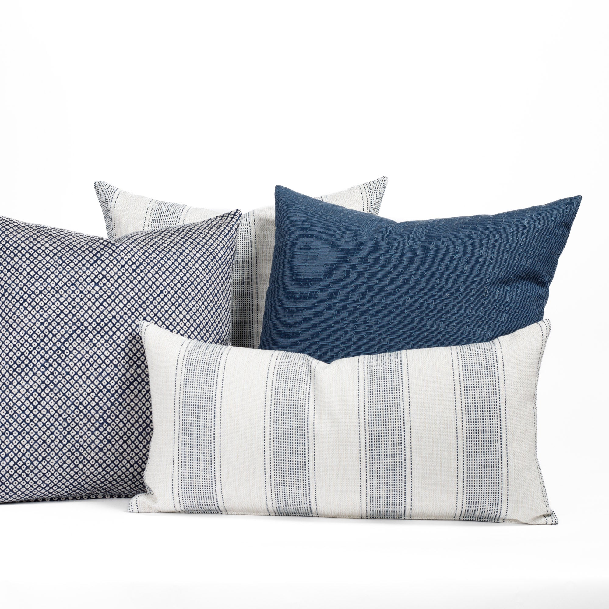 A selection of navy blue and white patterned indoor/outdoor pillows from Tonic Living.
