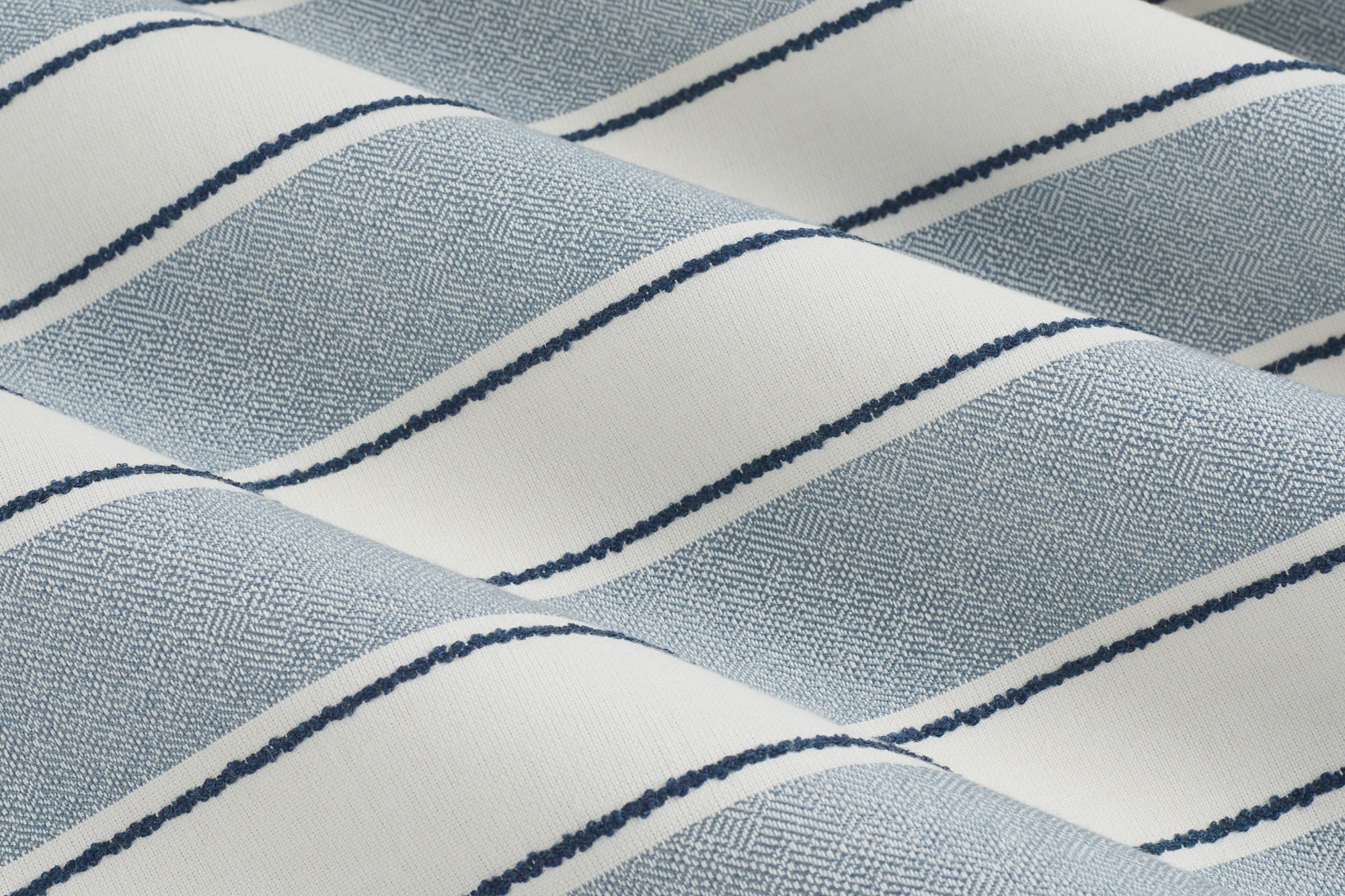 Tonic Living Sentiment Sunbrella Denim performance fabric showing movement in a bold blue striped design.