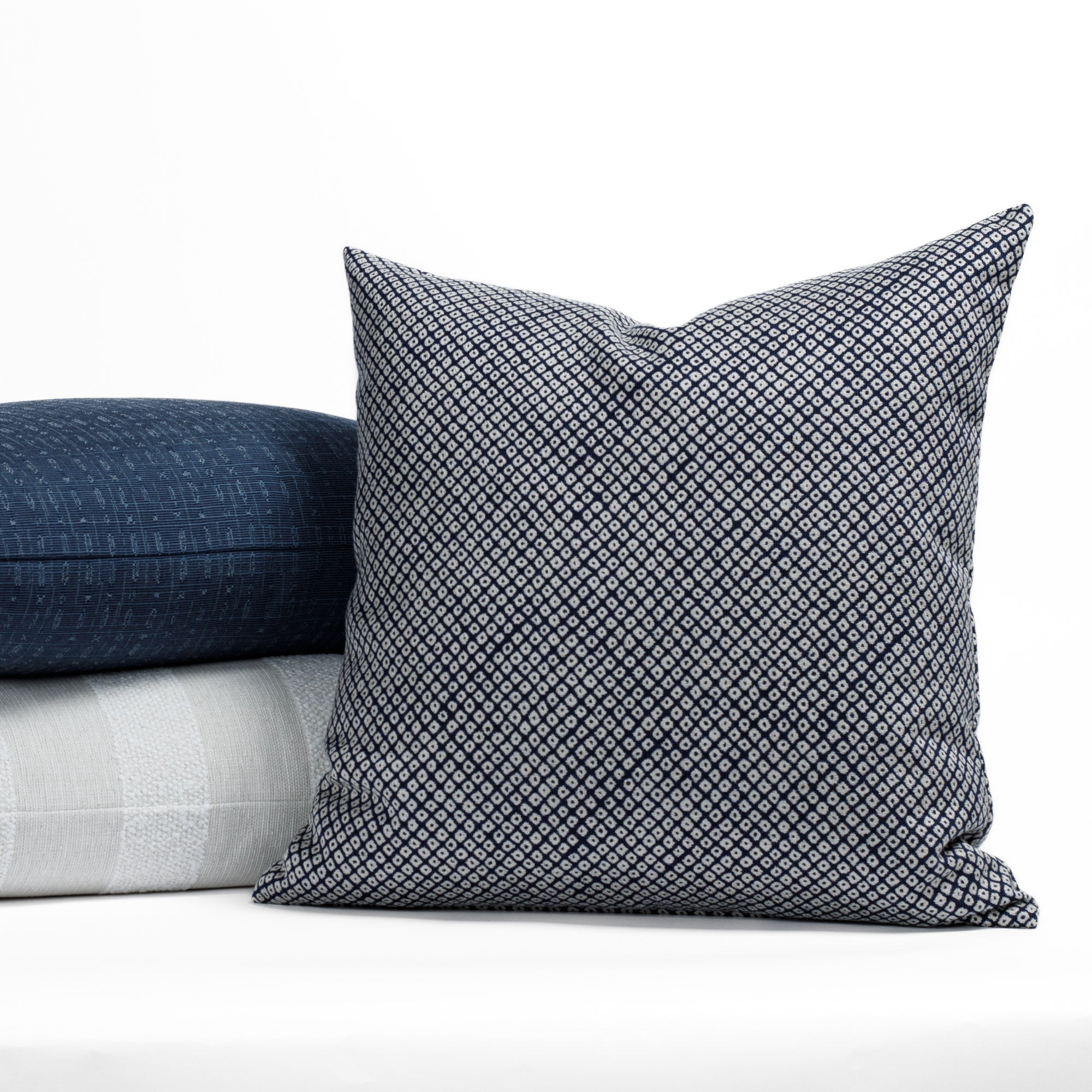 A selection of blue and white patterned indoor/outdoor designer pillows from Tonic Living.