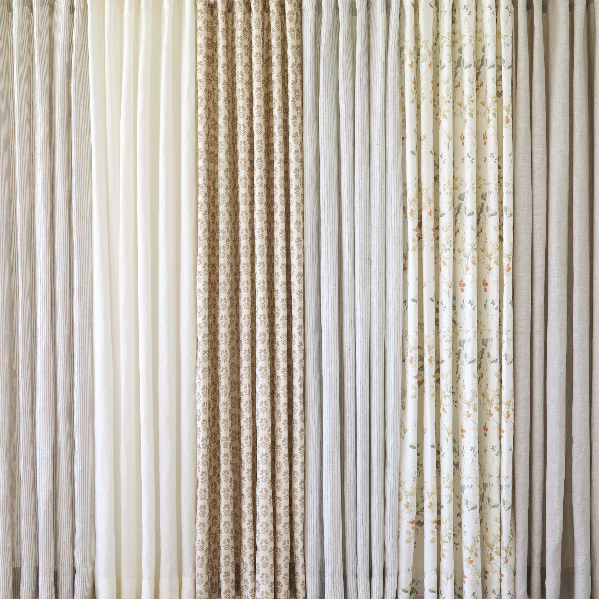 Tonic Living shower curtain collection featuring neutral linen curtains in ivory, black, stripe, and soft botanical patterns.