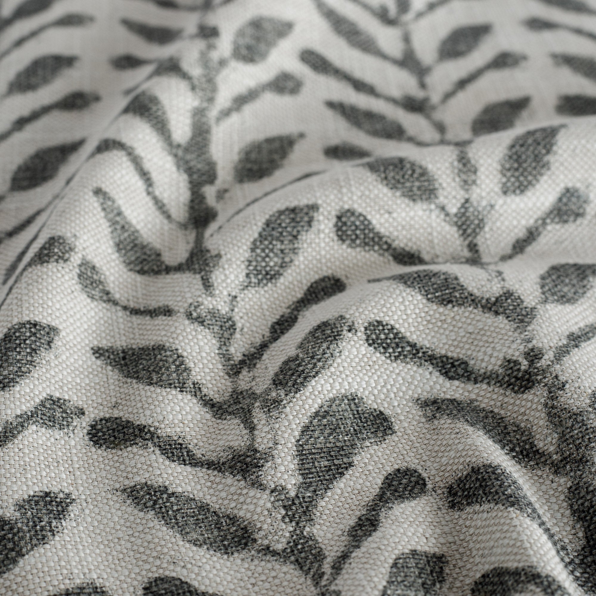 a charcoal grey and oatmeal beige botanical print fabric : close up view