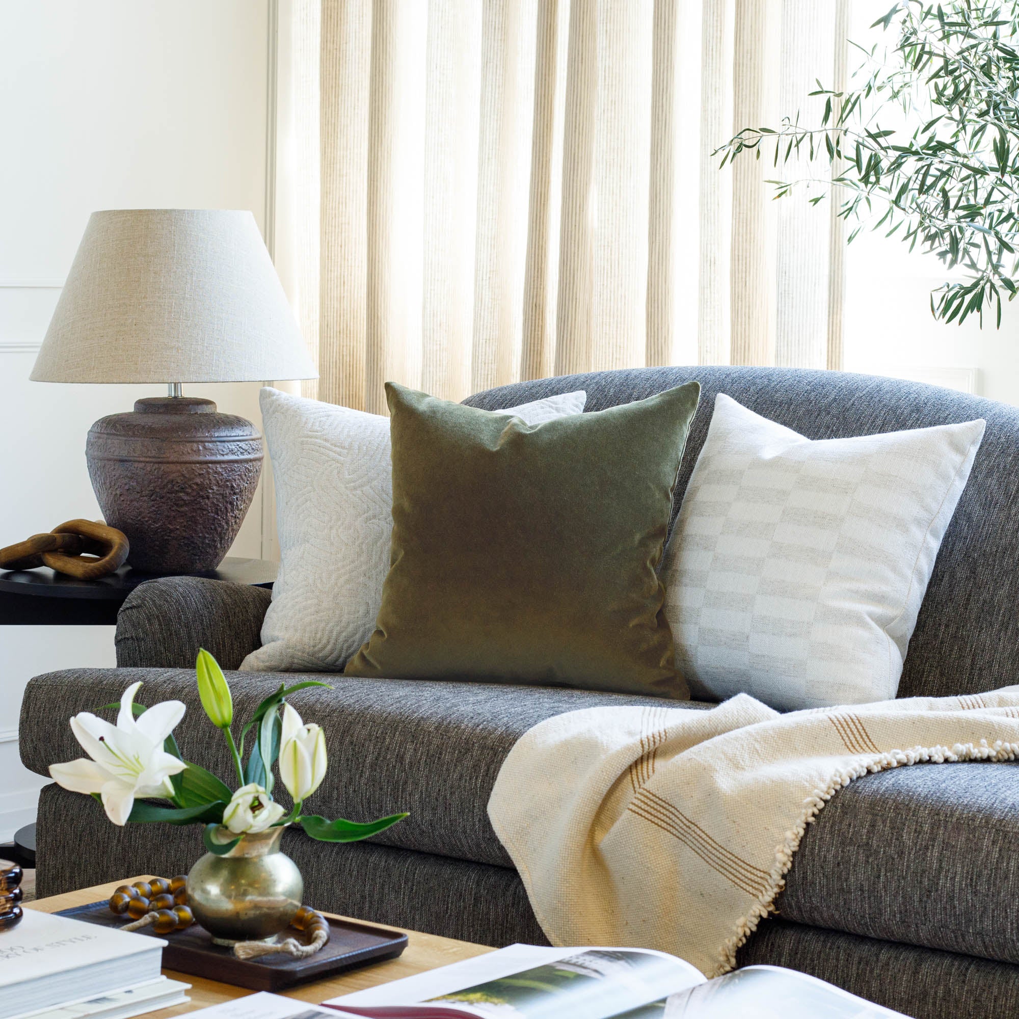 Tonic Living Valentina Velvet olive green throw pillow styled on a sofa with neutral cushions.