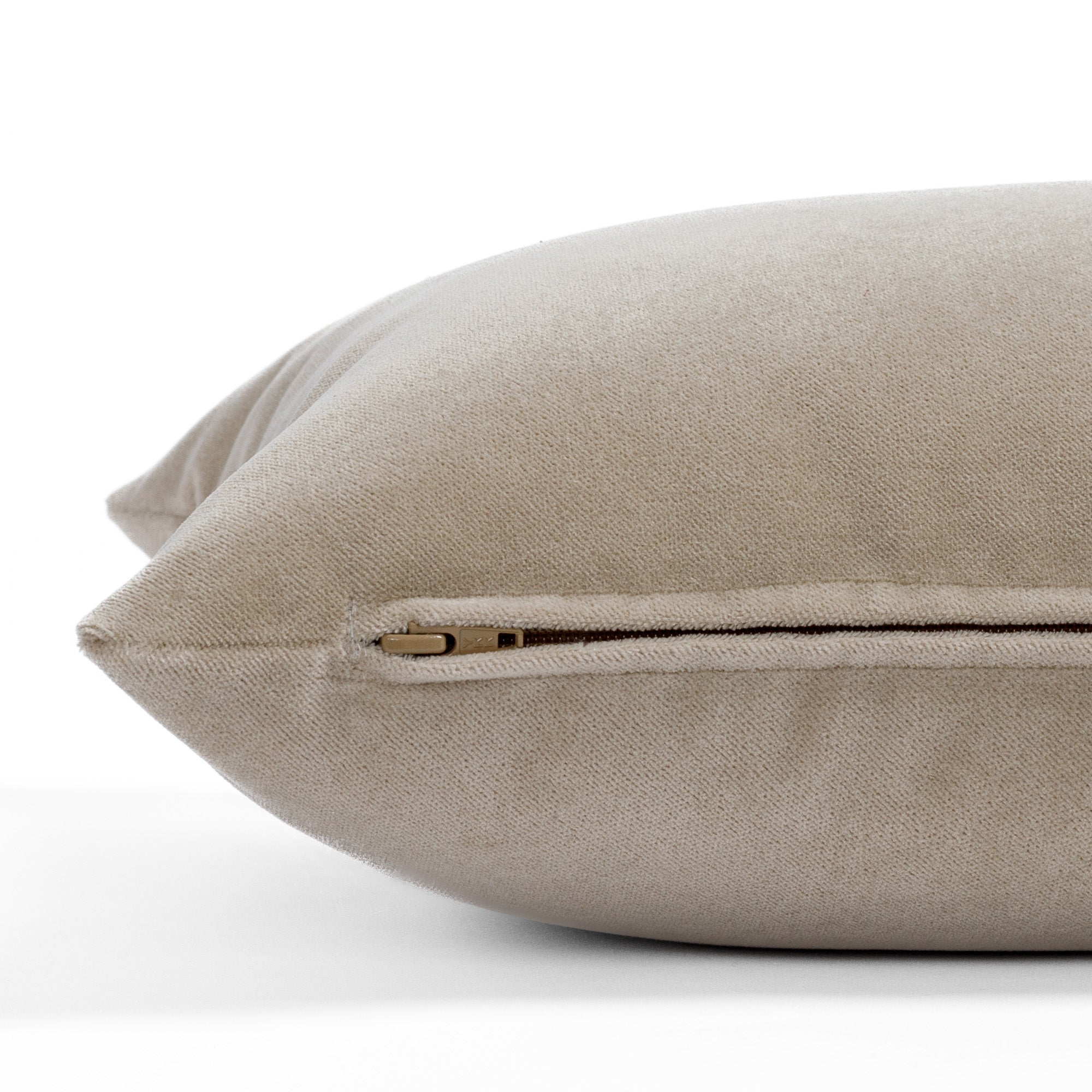 Valentina Velvet Cashmere 12x24 Lumbar Pillow from Tonic Living, a light camel beige velvet toss pillow with a subtle sheen: close-up zipper view.