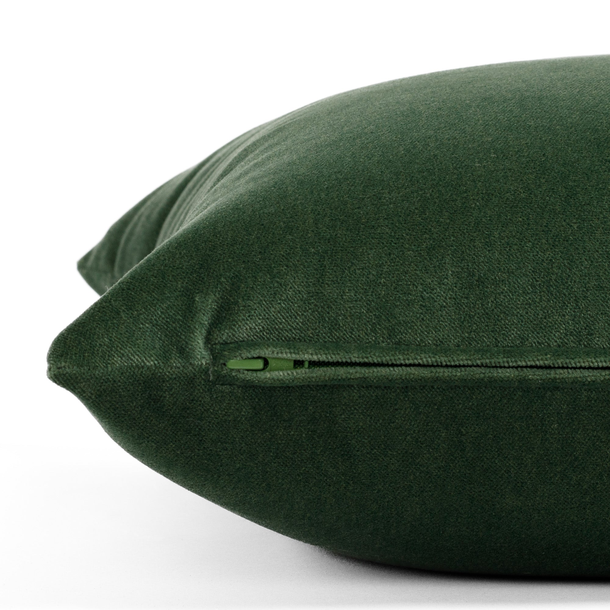 A plush, emerald green velvet throw pillow from Tonic Living: close up zipper view.