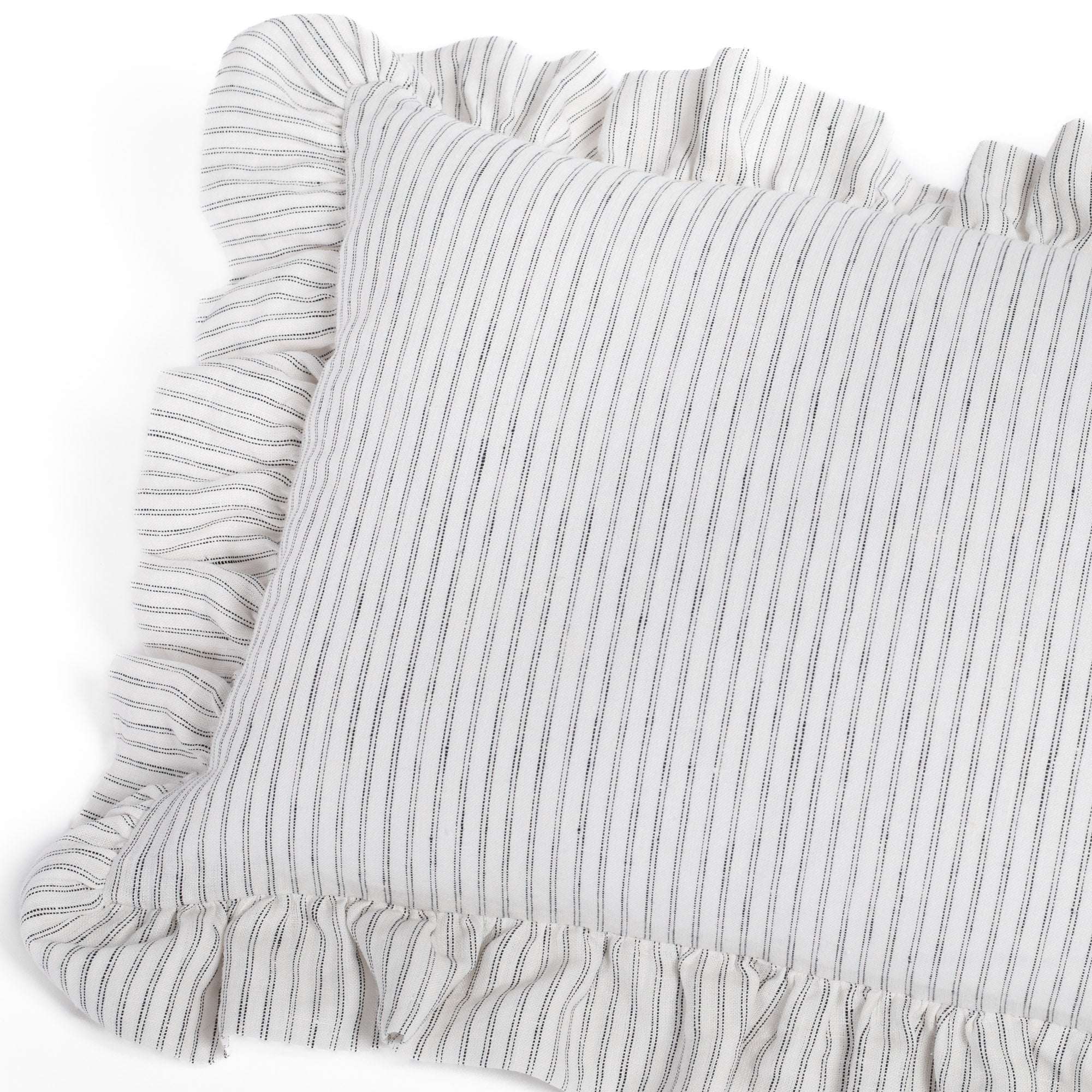 Angled view of the Verona Jet 14x20 ruffled lumbar cushion from Tonic Living, capturing its soft drape, airy linen texture, and charming silhouette.